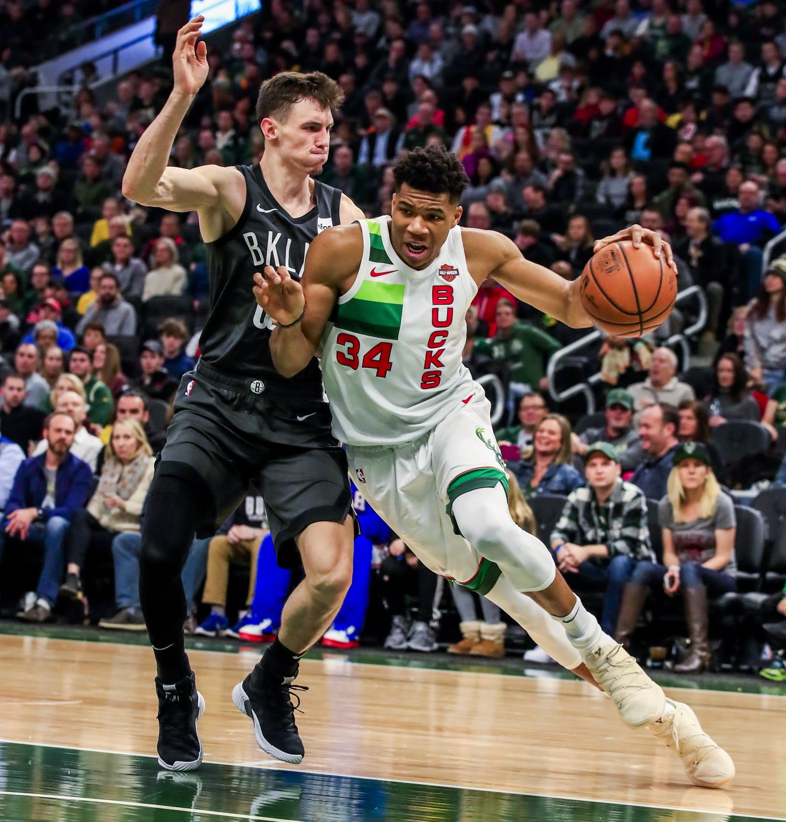 Rodions Kurucs defendiendo a Giannis Antetokounmpo.
