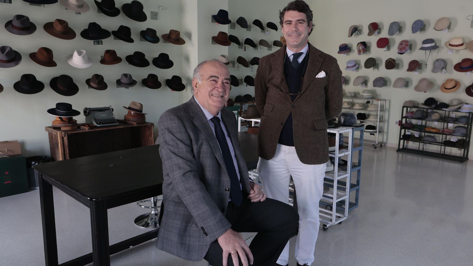 Enrique Fernández y Miguel García junto a un expositor de sombreros.