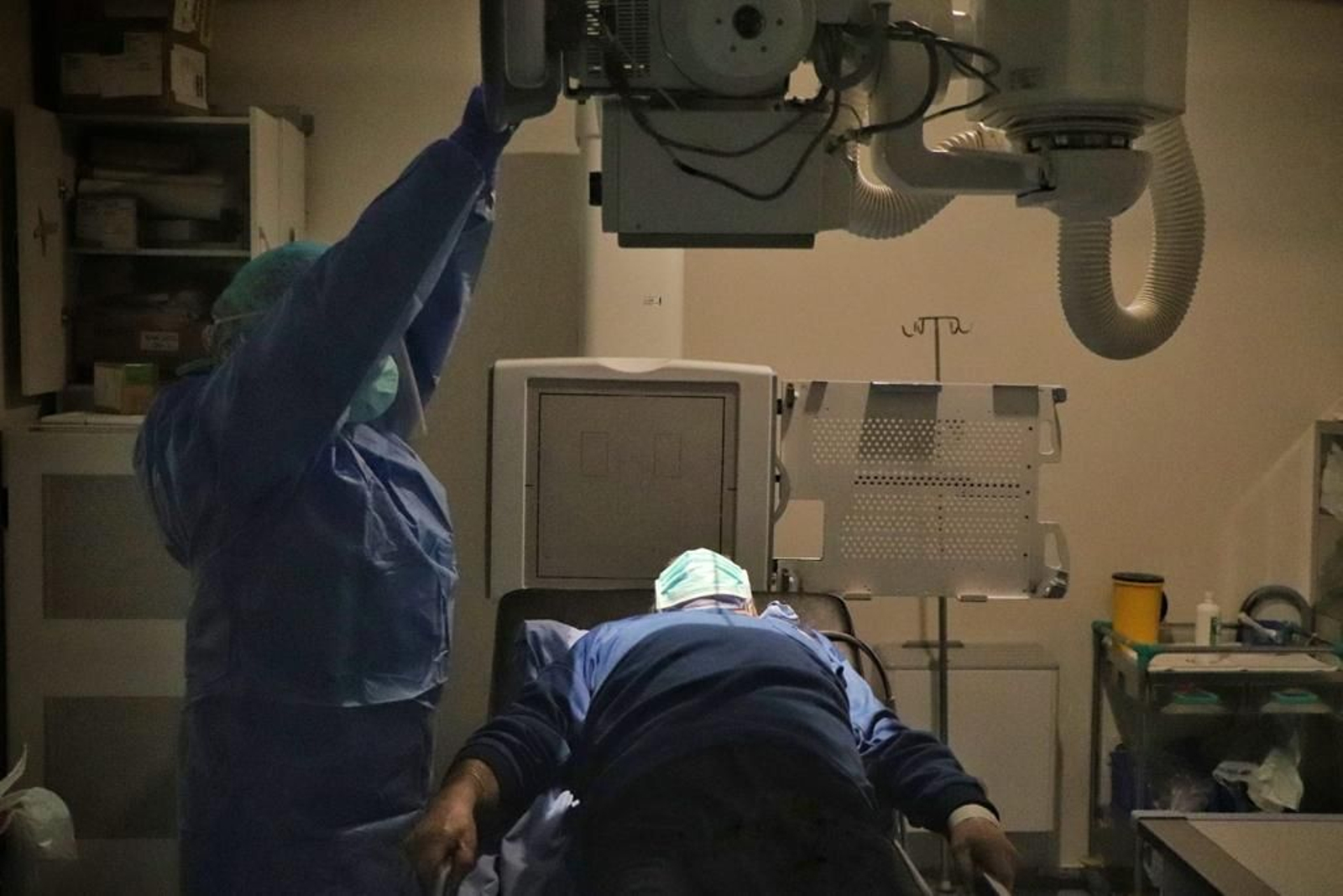 Un profesional sanitario realiza una placa a un paciente.