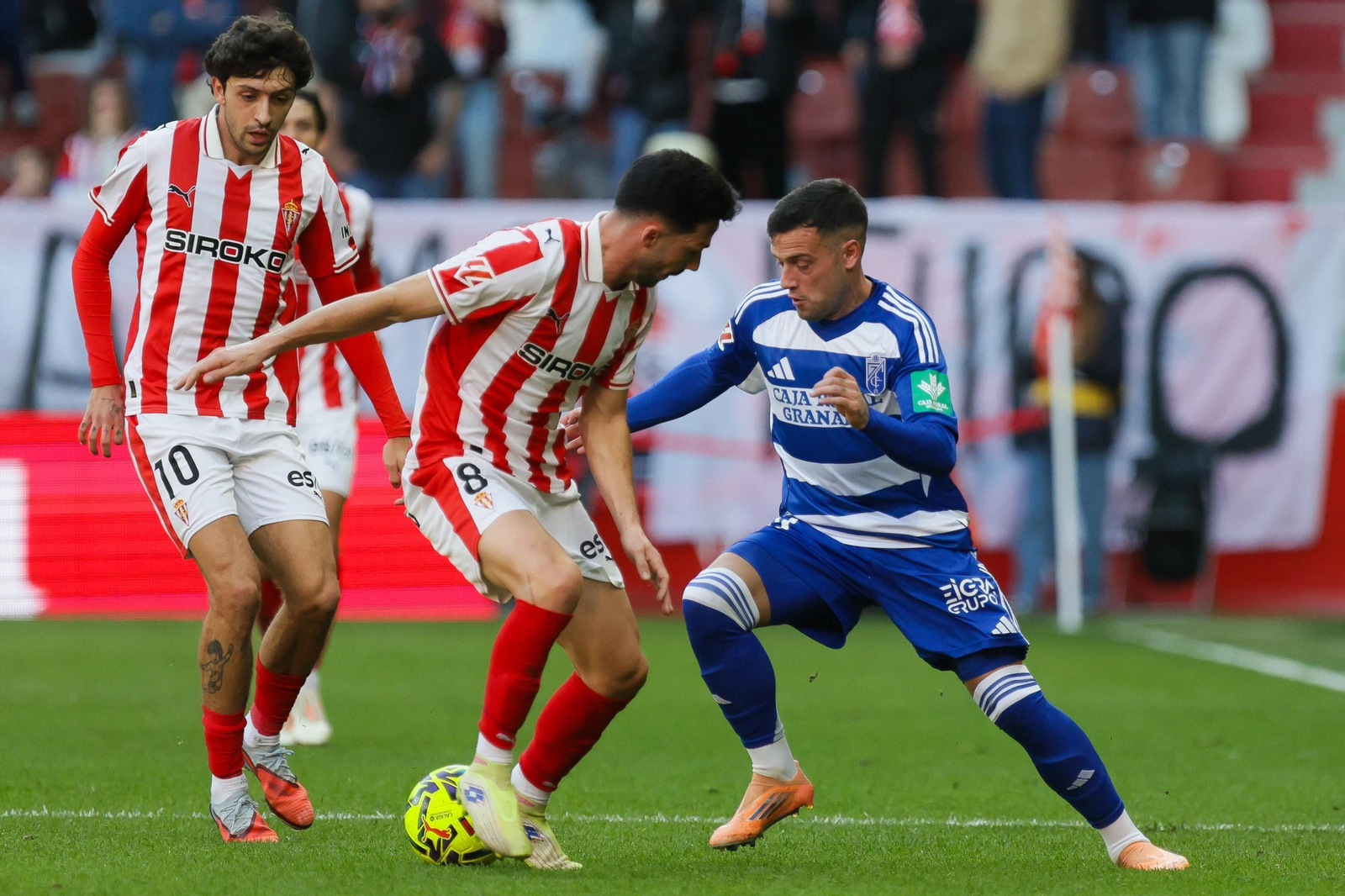 José Arnáiz regateando a un zaguero del Sporting durante el partido.