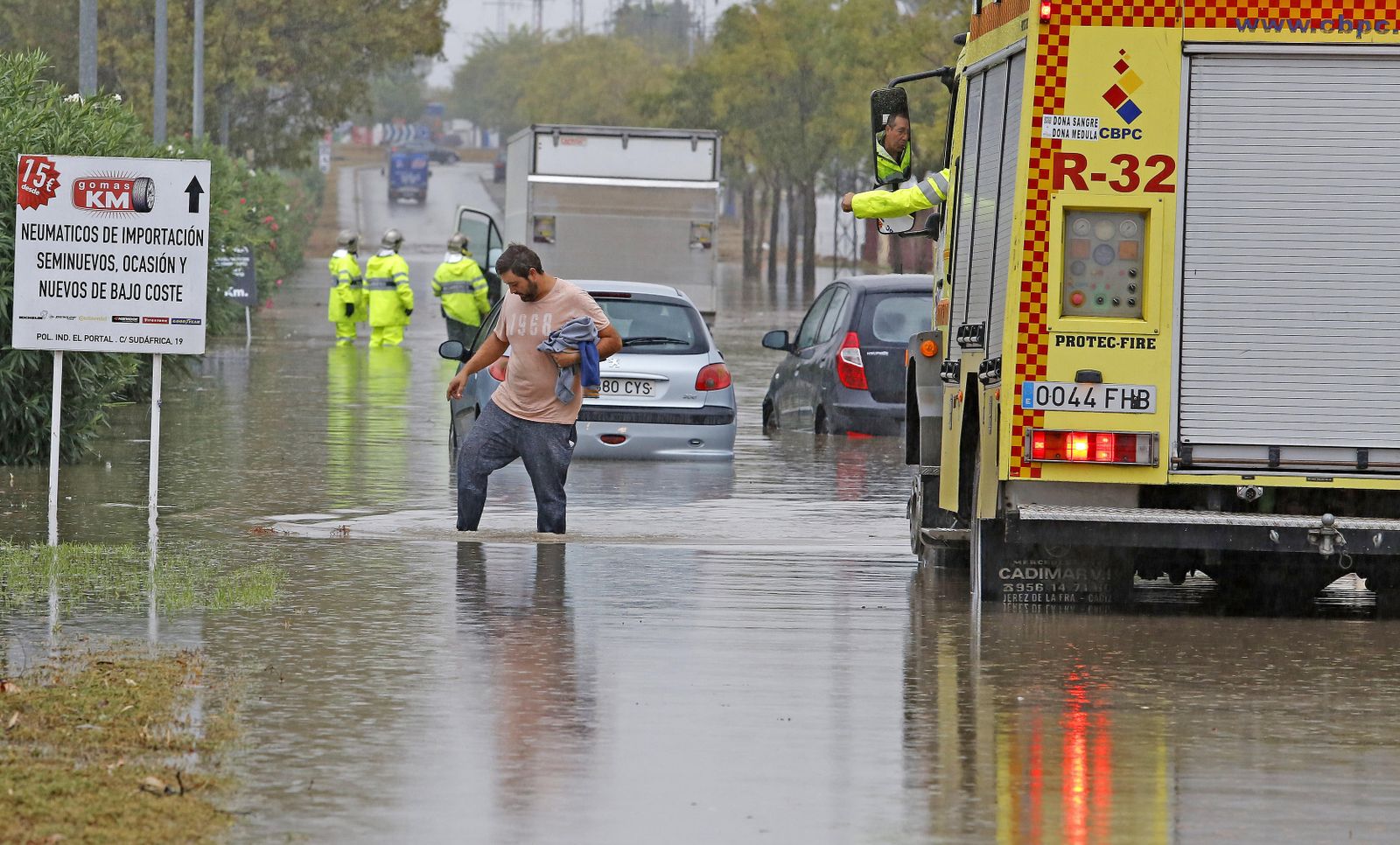 Un trabajador, con el agua casi en las rodillas, en el polígono industrial El Portal.