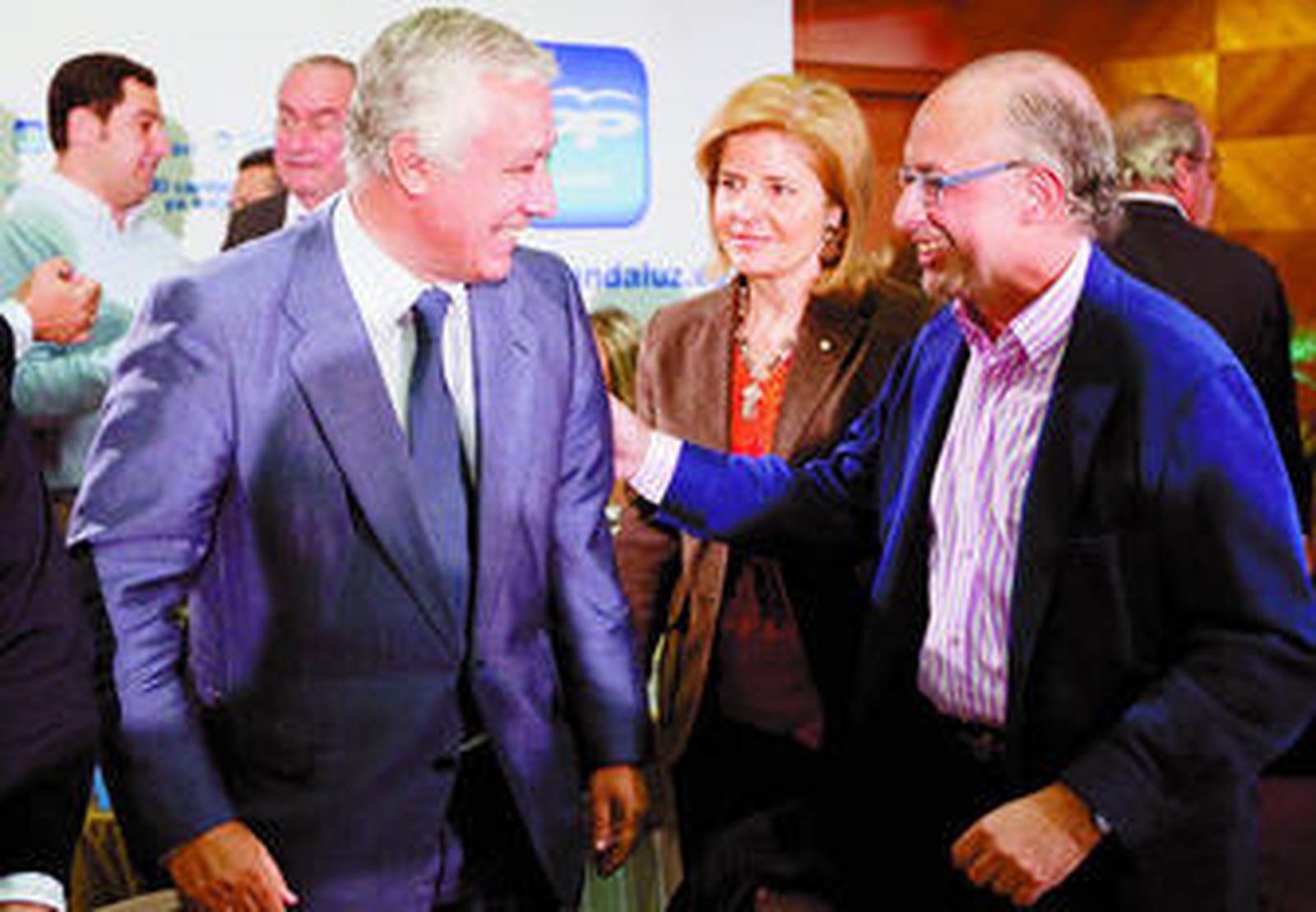Javier Arenas recibe el saludo de Cristóbal Montoro ante la mirada de Esperanza Oña, ayer en Sevilla.