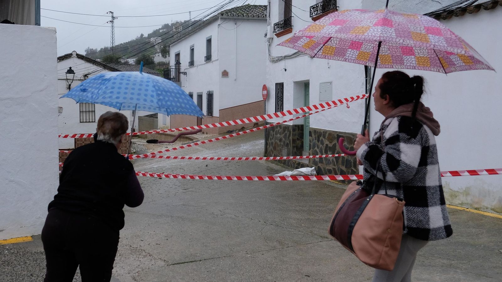 Vecinas observan el brote de agua en las calles.
