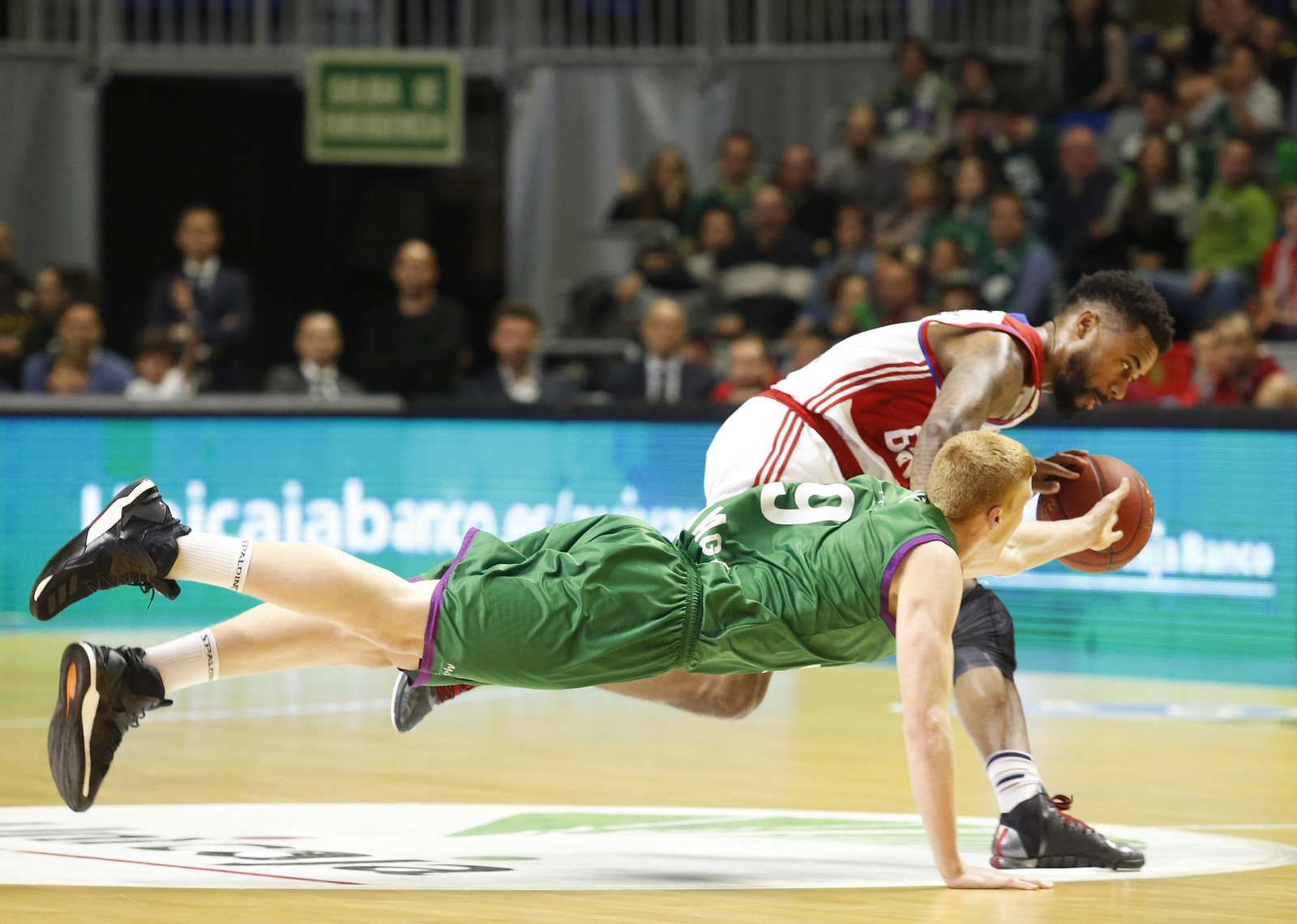 Alberto Díaz se lanza a la disputa de un balón perdido con Bryce Taylor durante el Unicaja-Bayern.