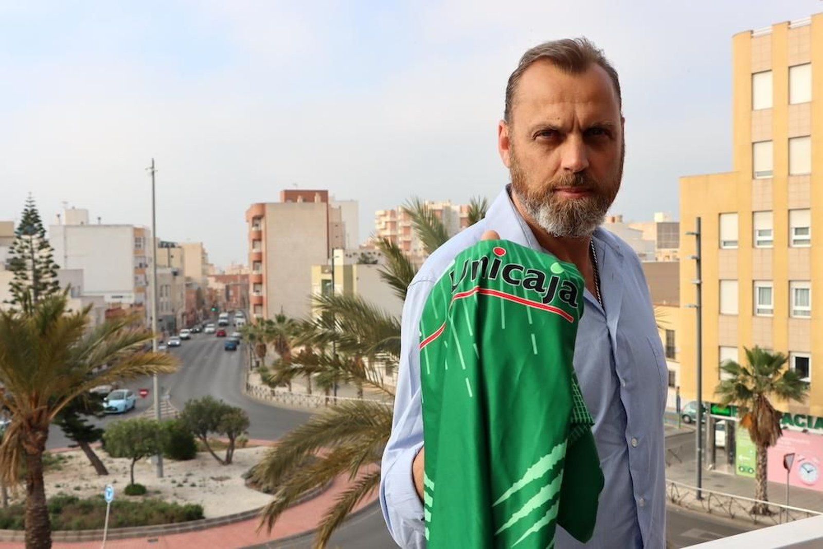 Charly Carreño posa en la rampa del Moisés Ruiz sujetando una camiseta del conjunto verde.