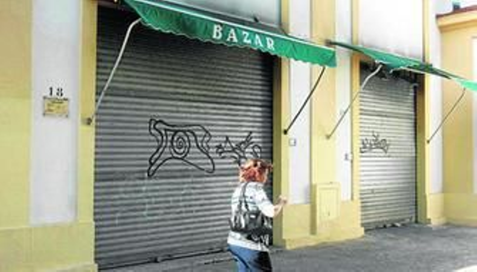 Una mujer pasa ante la tienda siniestrada de La Asunción ayer.