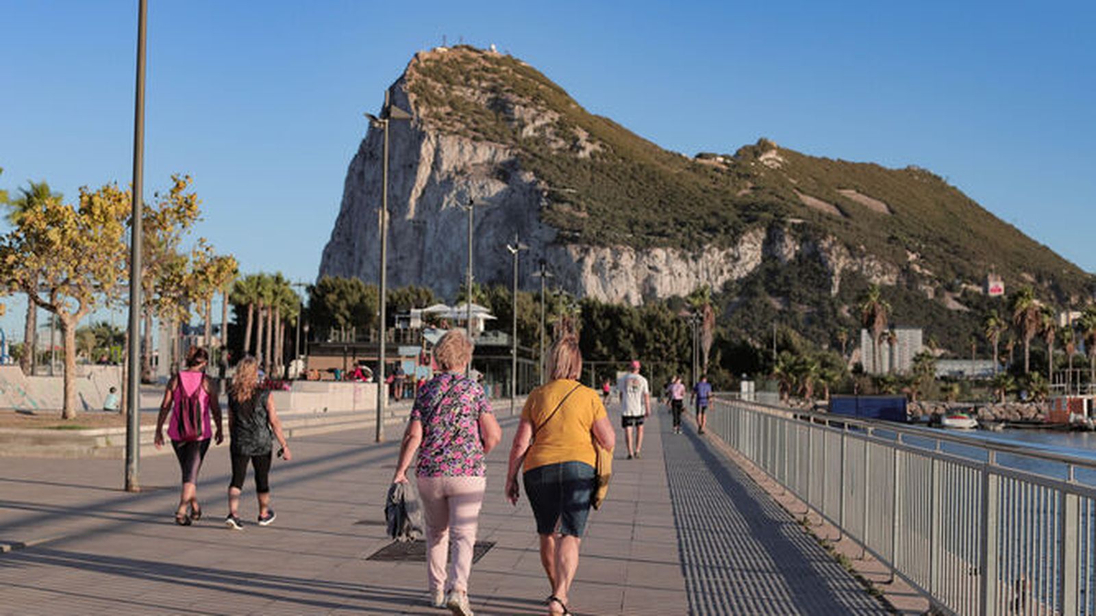 Varias personas caminan por el paseo Marítimo de La Línea.