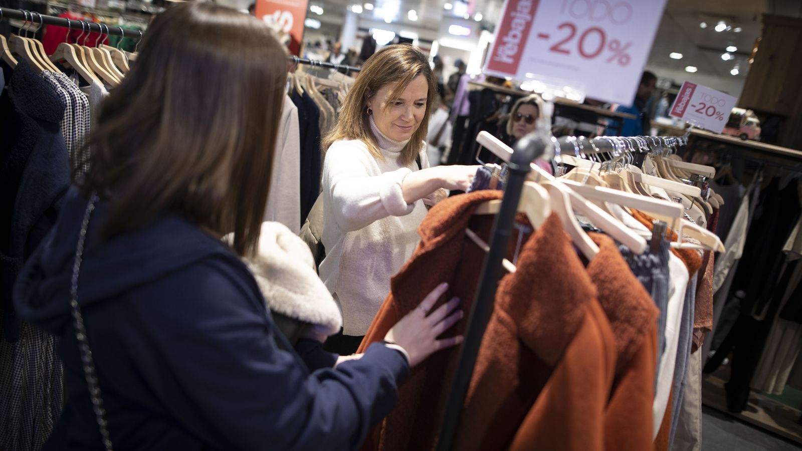 Dos mujeres buscan una oferta en un perchero de un comercio