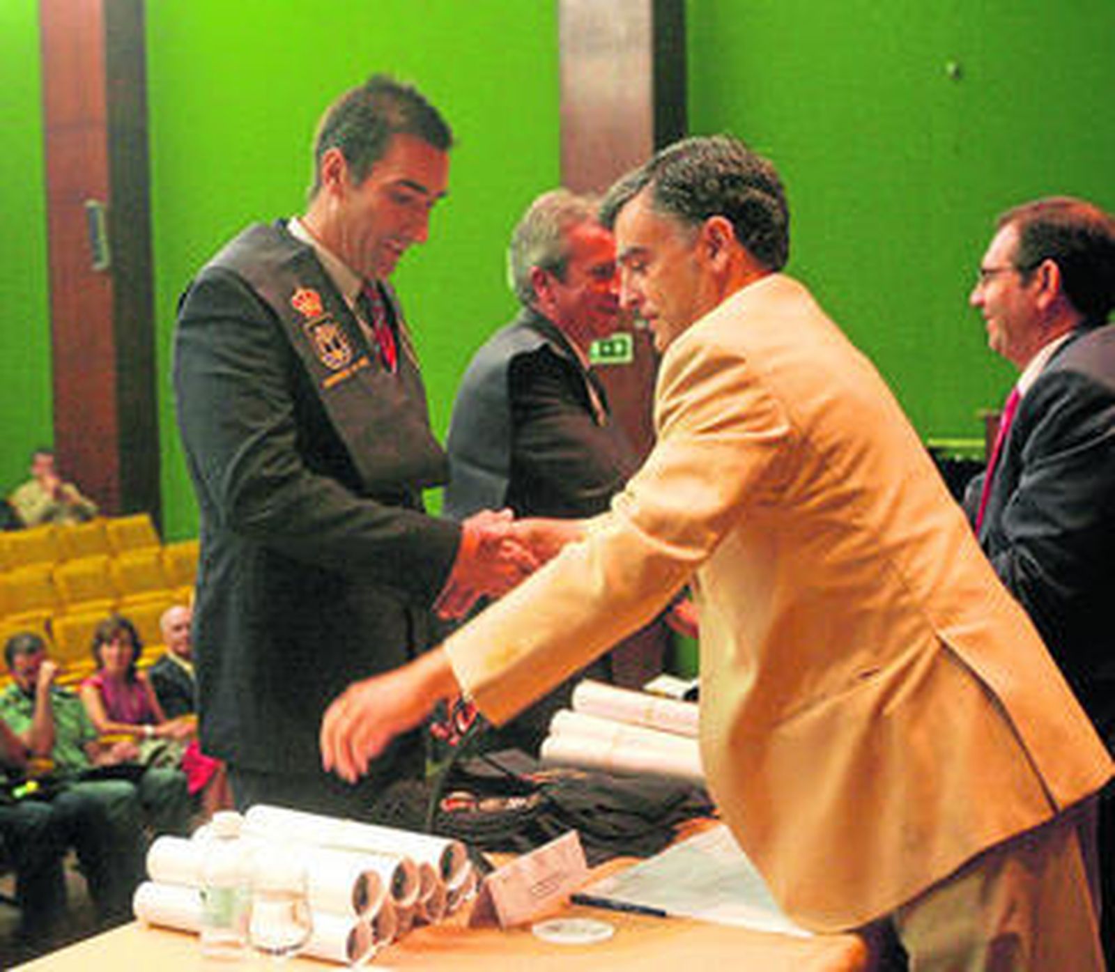 Dos alumnos recogen su título de Experto en Criminología, ayer, durante el acto de graduación.