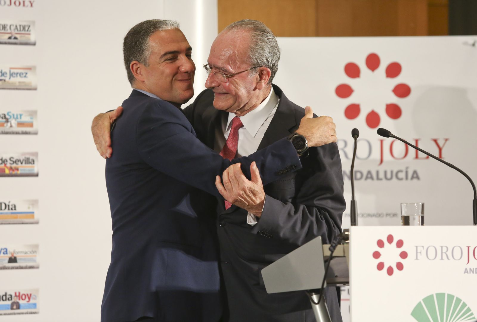 Elías Bendodo y Francisco de la Torre se dan un abrazo en un foro organizado por Grupo Joly