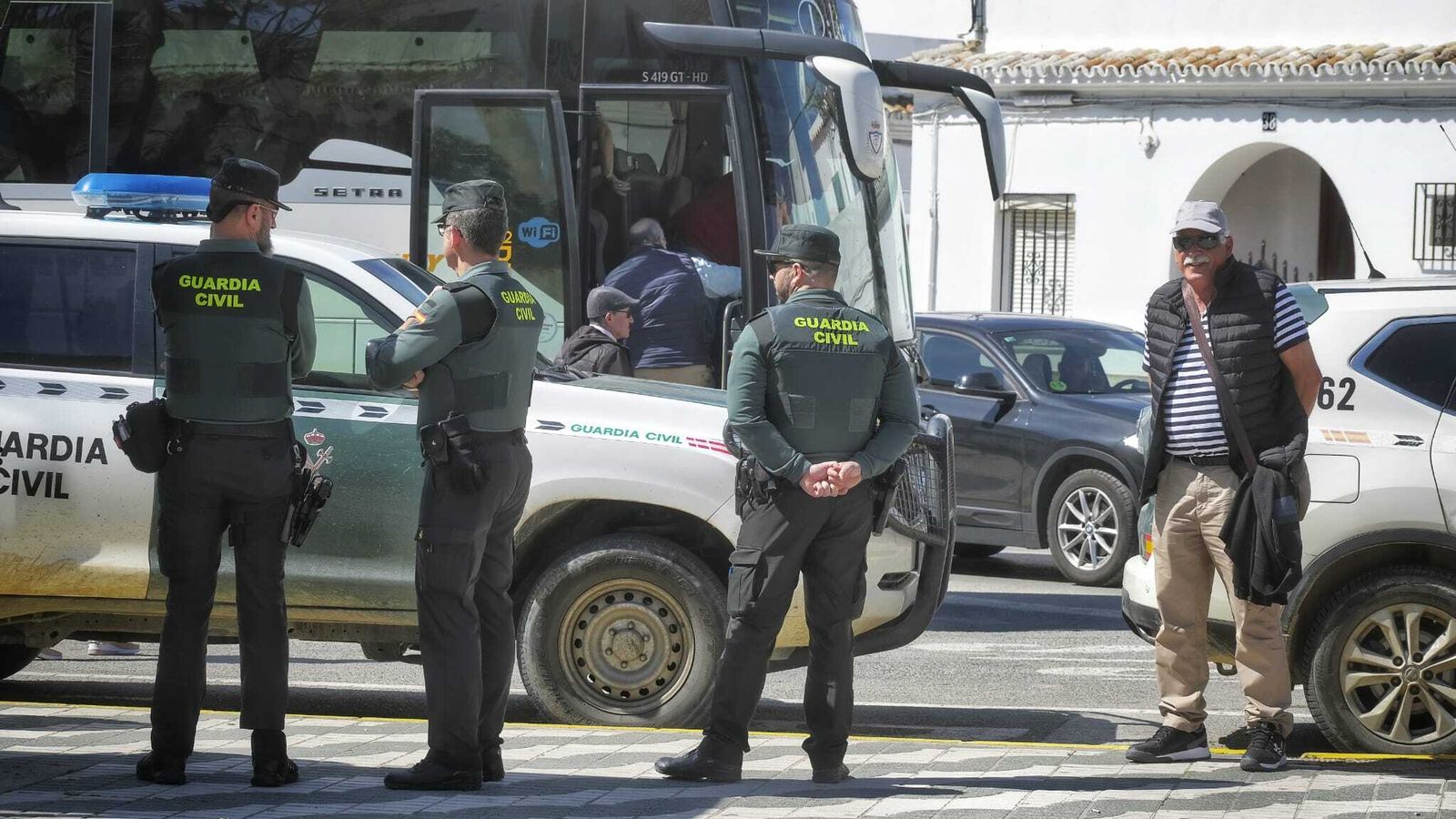 Turistas y curiosos frente al operativo de la Guardia Civil en Barbate