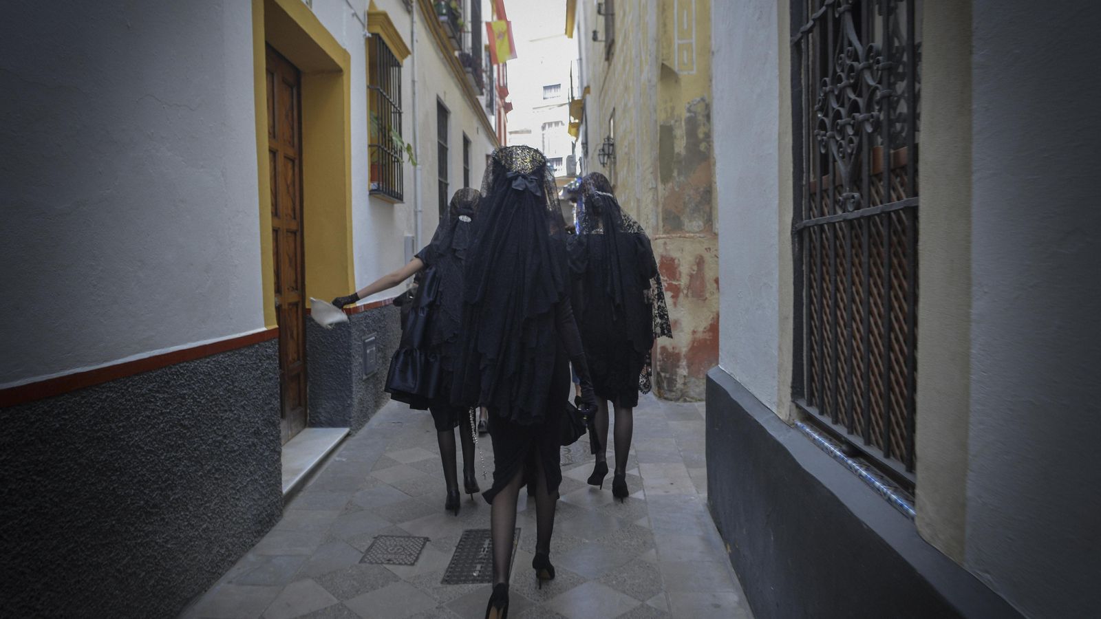 Mujeres de mantilla se pierden por el Barrio de Santa Cruz.