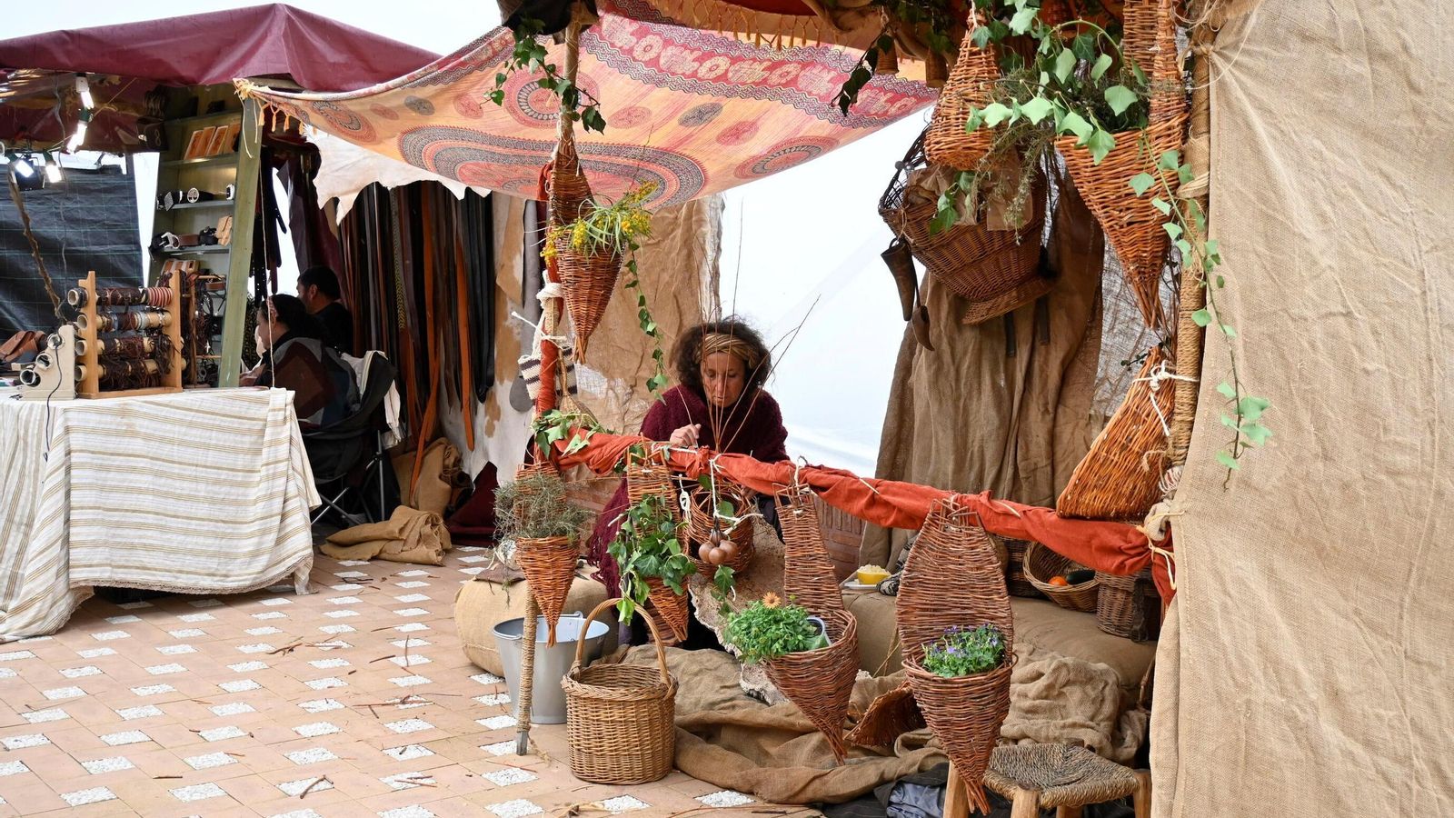 Una mujer realiza productos artesanales para su puesto en la Feria Medieval.