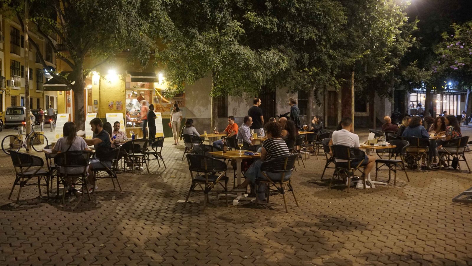 Velador repleto de clientes en un bar de la Alameda de Hércules.