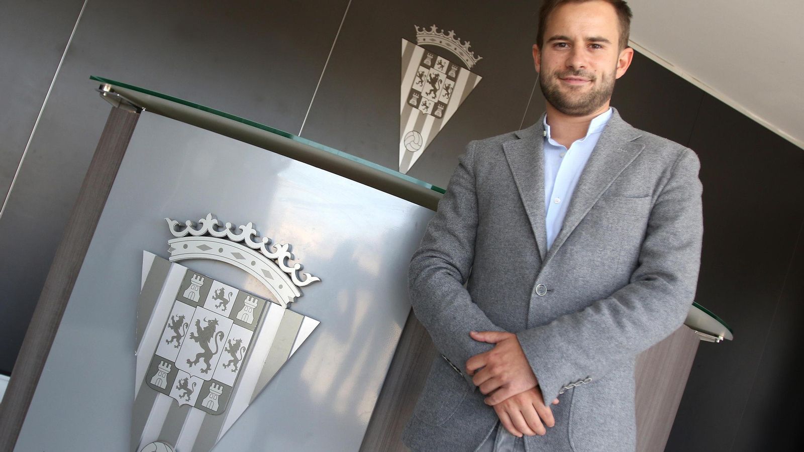 Alejandro Gonzáez posa junto al escudo del Córdoba en el estadio