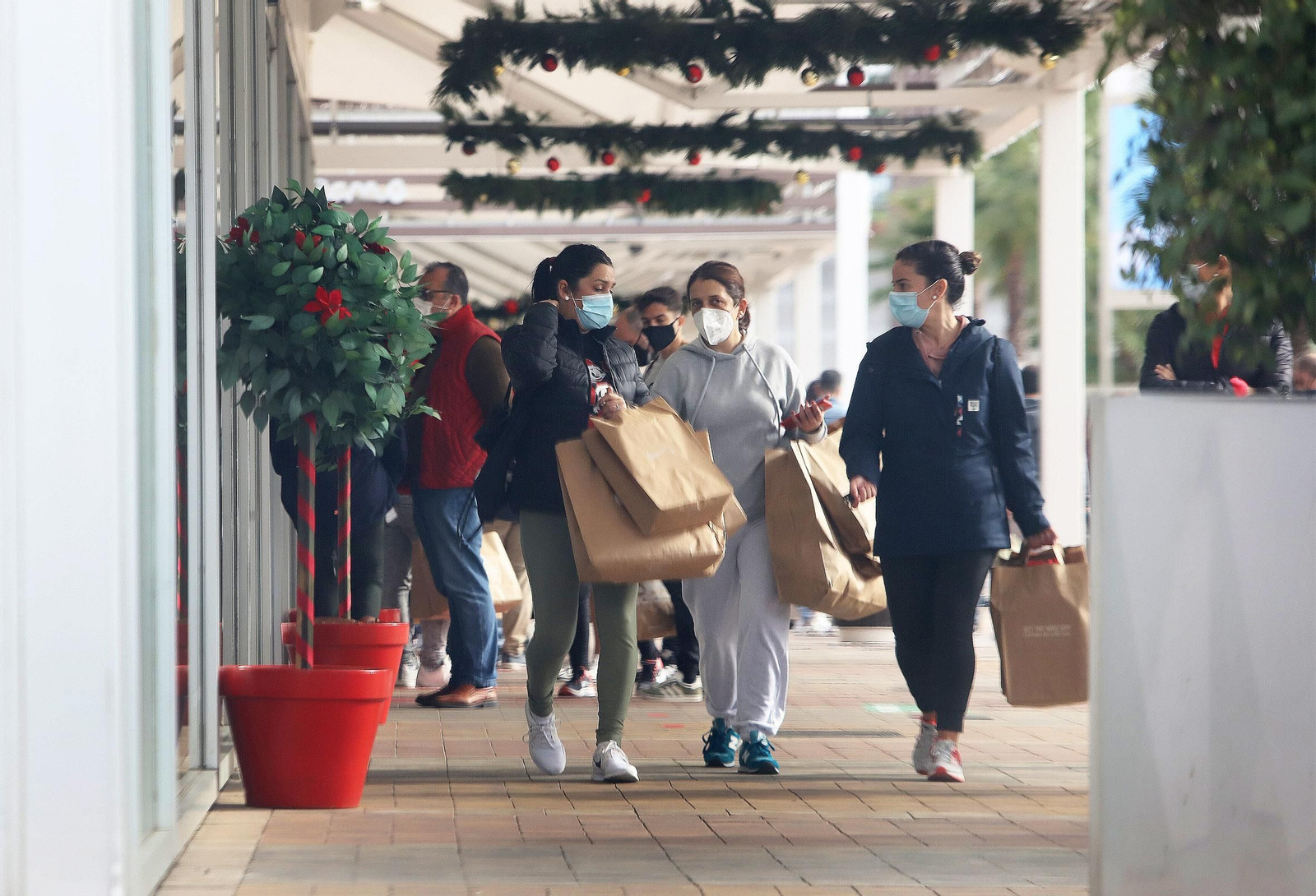 Tres clientes caminando por el centro comercial de Luz Shopping