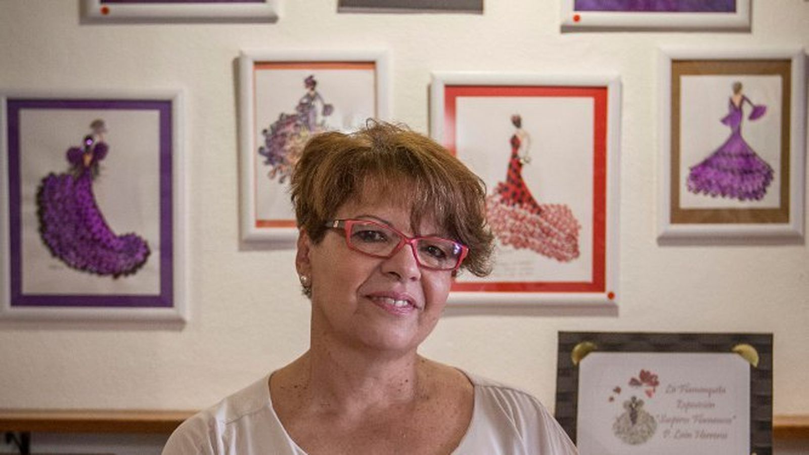 Paqui León Herrero, con algunos de sus cuadros al fondo.