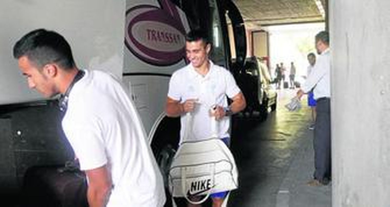 Jorge Sánchez mete la maleta en el autobús junto a Jaime Romero antes de viajar a La Manga en pretemporada.