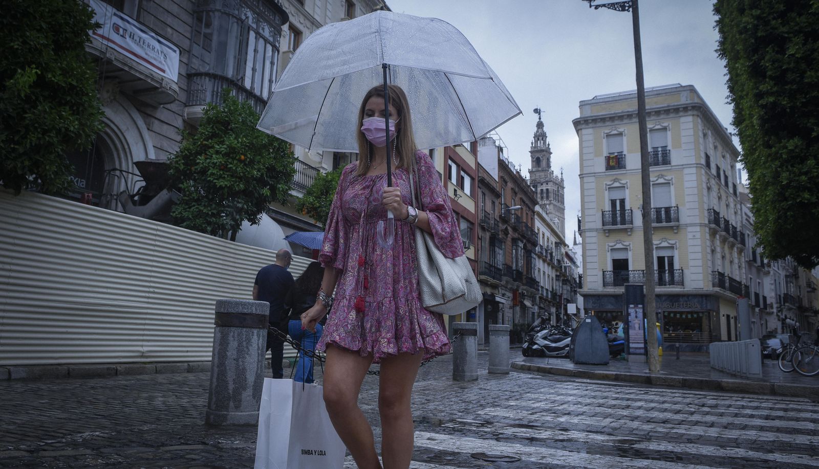Una mujer pasea por el centro de Sevilla con un paraguas