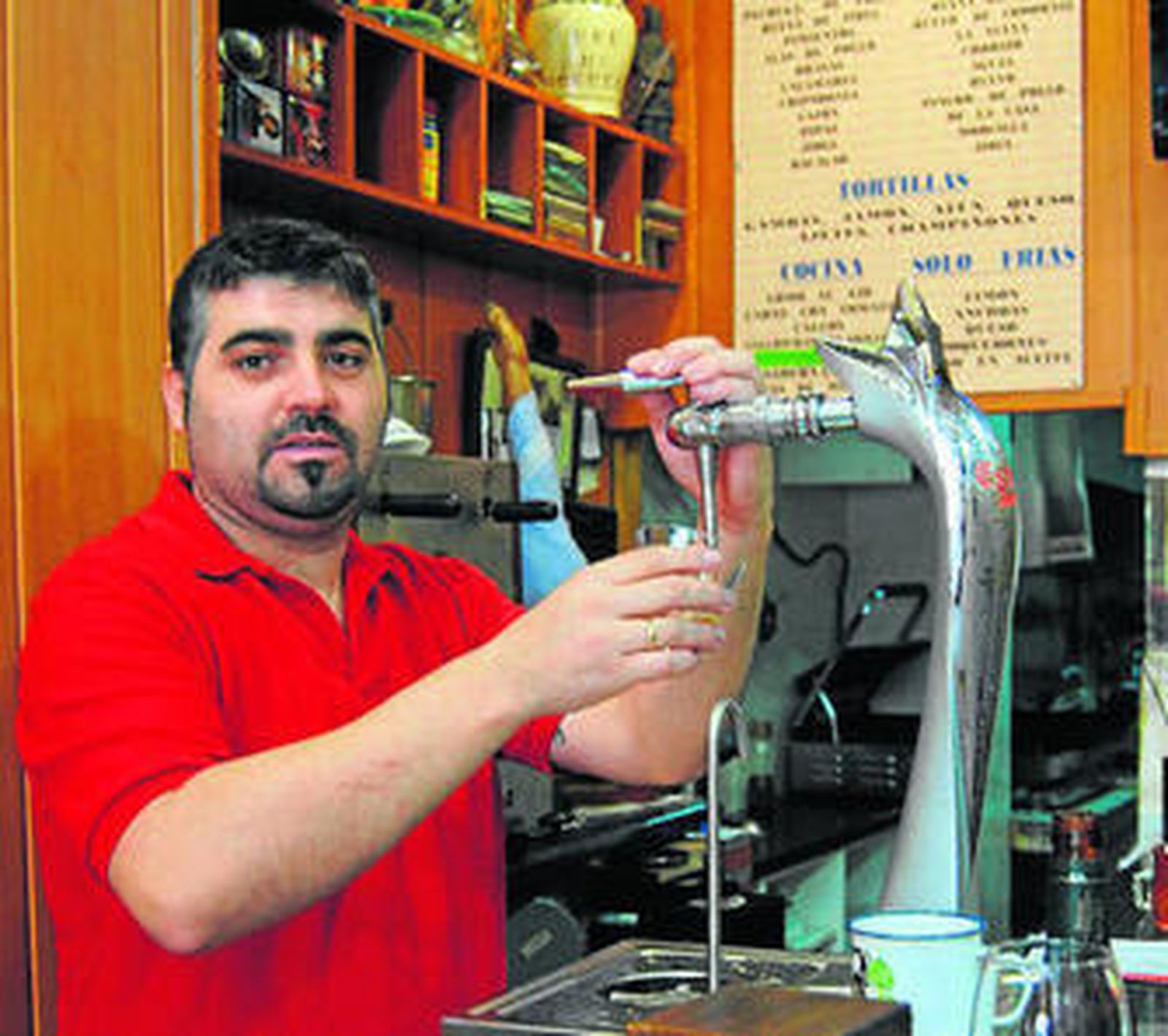 Jose, dueño y camarero, tira una caña en la barra del bar.