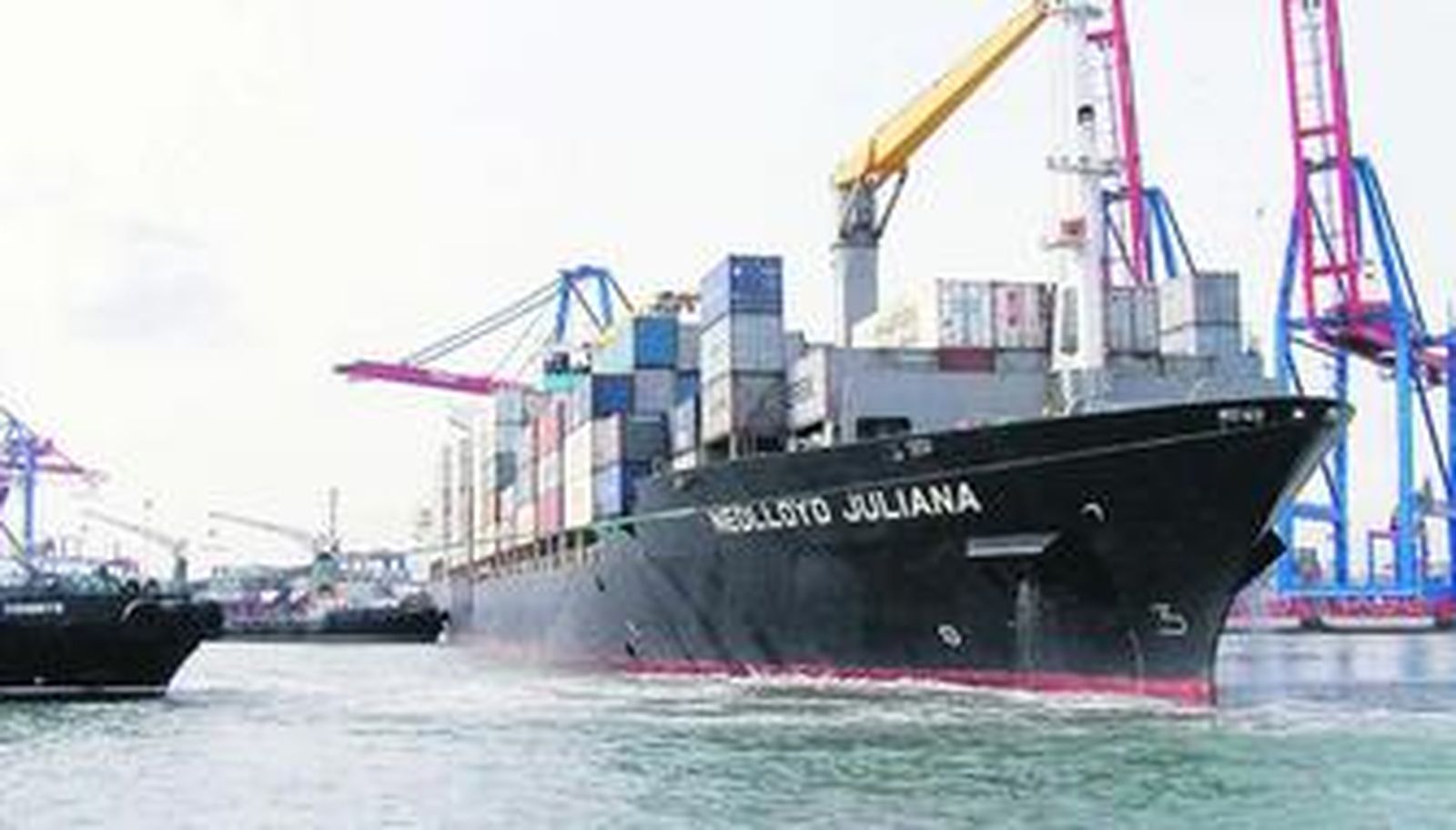 Remolcadores en una maniobra con un buque portacontenedores.