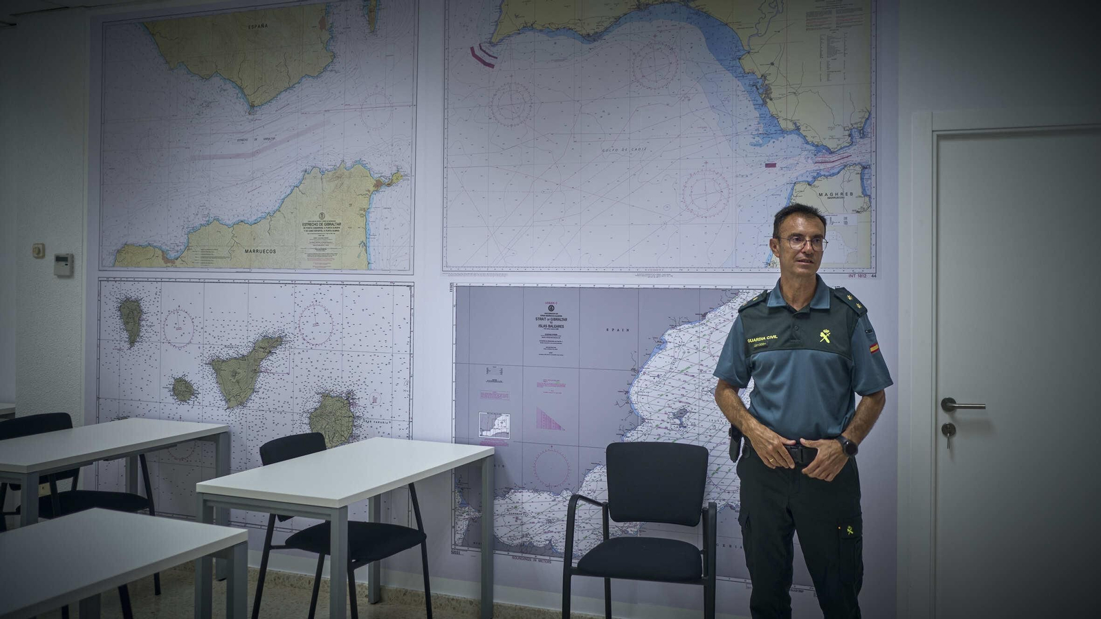 El teniente coronel Guijo posa en una de las aulas de la escuela con cartas náuticas a su espalda.