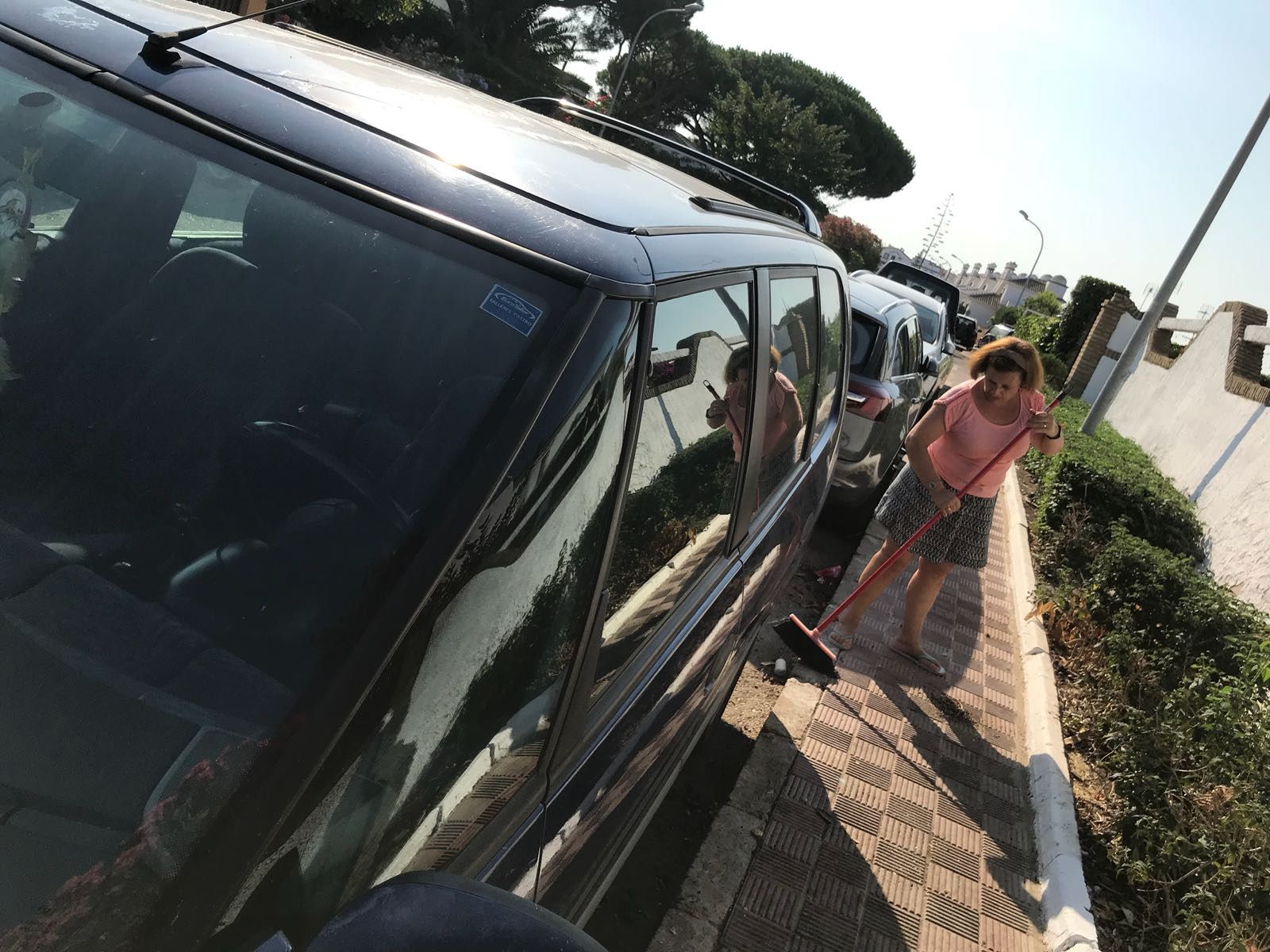 Una vecina limpia la zona donde estaban situados los contenedores