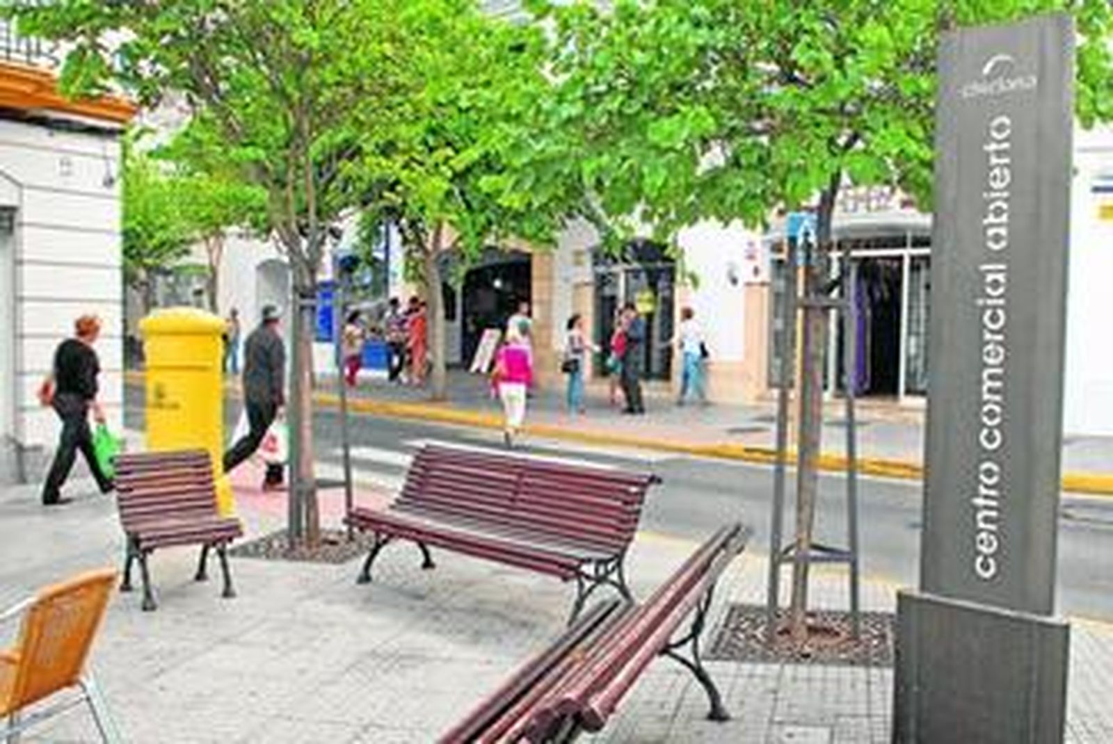 Una de las calles del casco urbano con el antiguo soporte informativo del Centro Comercial Abierto.