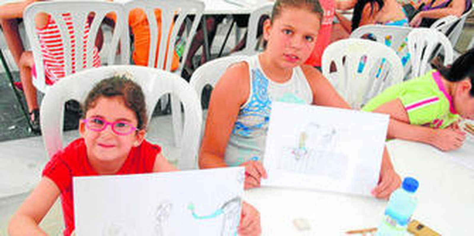 Alba, de cinco años, y Teresa, de once, dibujan su versión de la Feria.