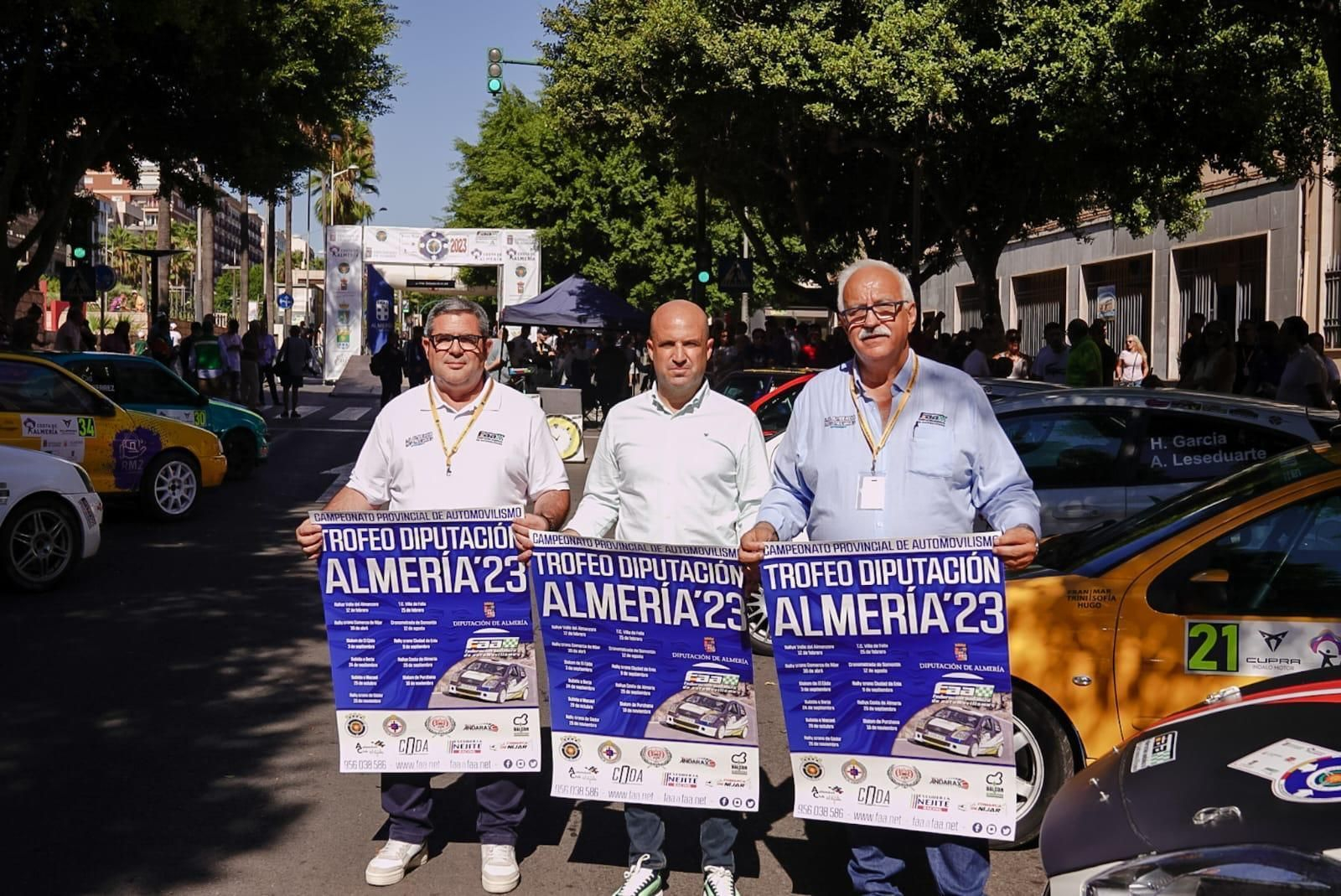 El diputado de Deportes y el presidente de la Federación Andaluza posan con el cartel del Campeonato Provincial de Automovilismo.