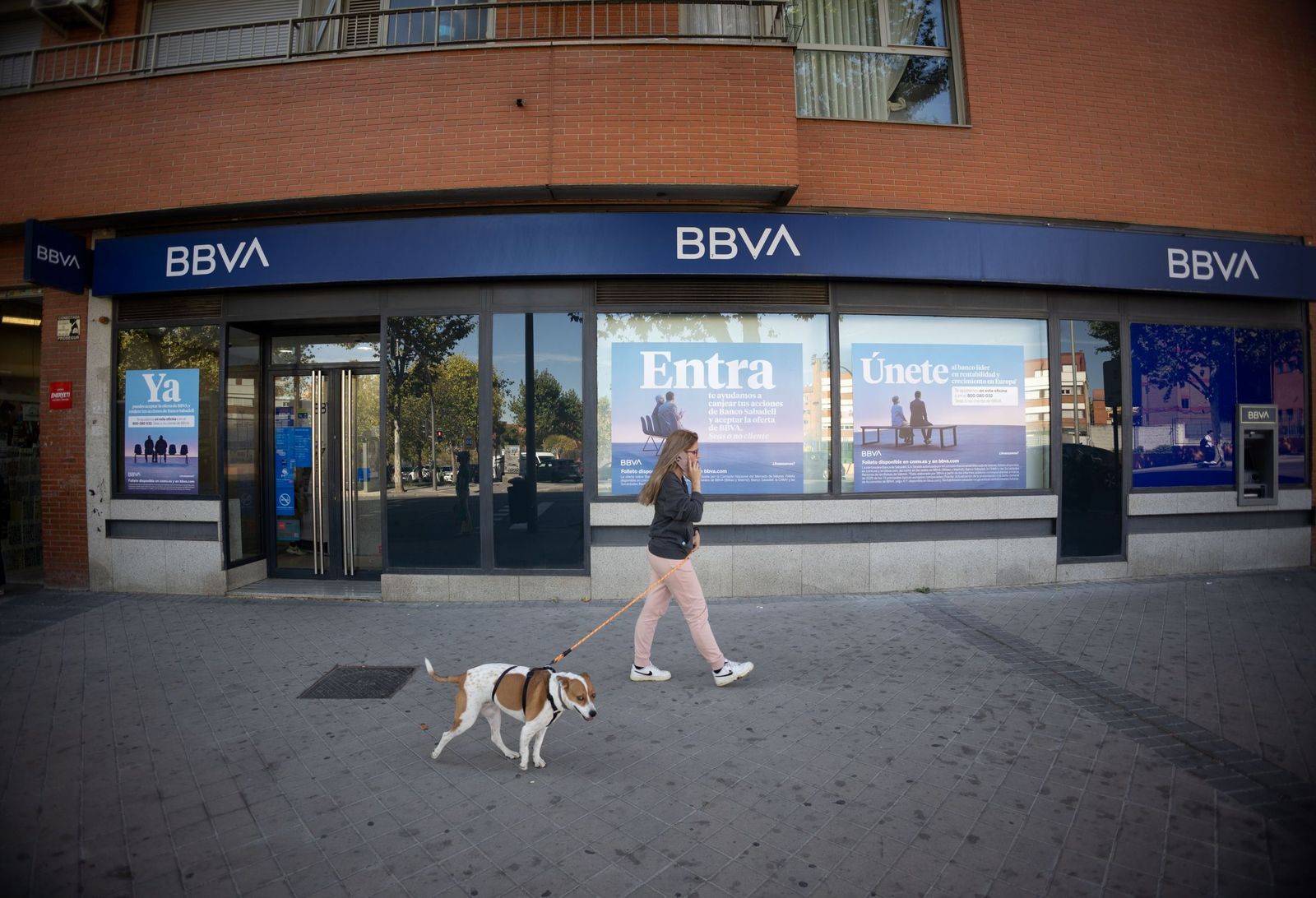 Una persona pasea con su perro frente a una oficina del banco BBVA. Los depósitos bancarios en la provincia de Almería rozan los 15.000 millones de euros según los últimos datos del Banco de España.