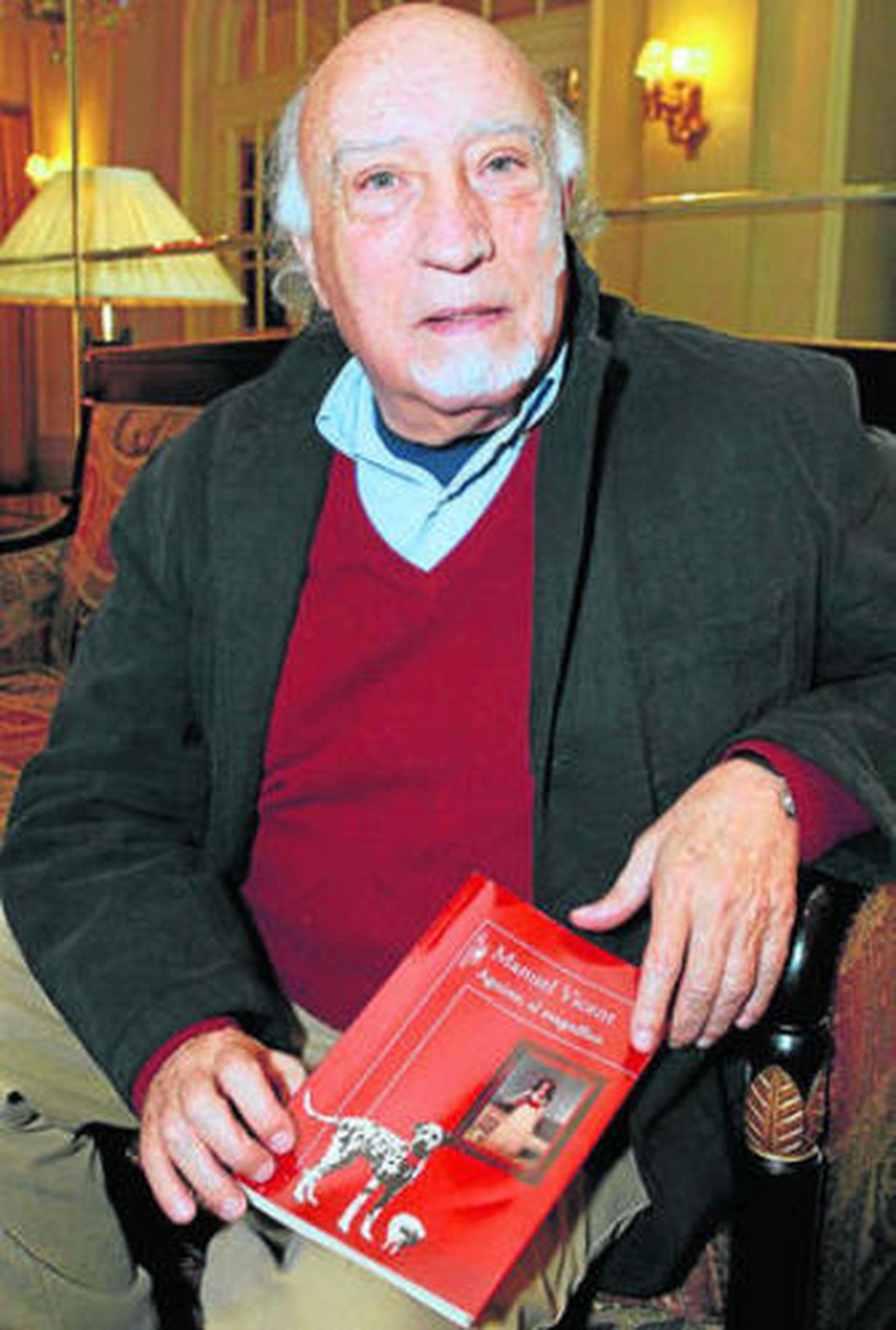 Manuel Vicent con un ejemplar de su obra, editada por Alfaguara.