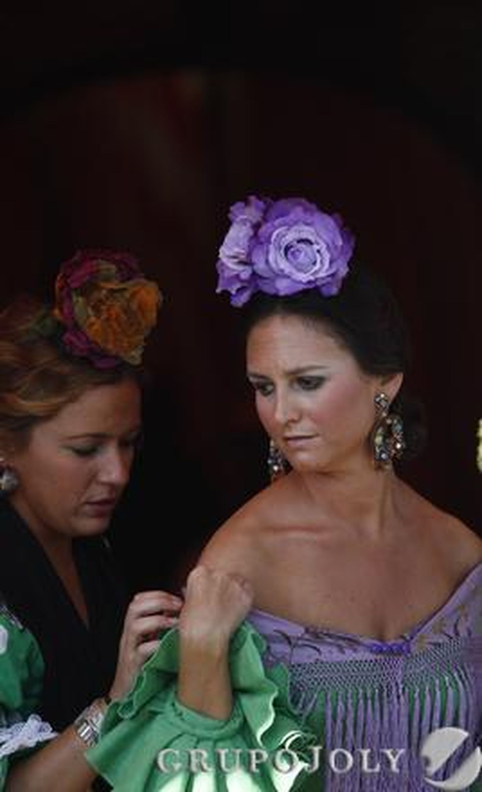 Un chica coloca el mantón a otra en el Real.

Foto: Antonio Pizarro