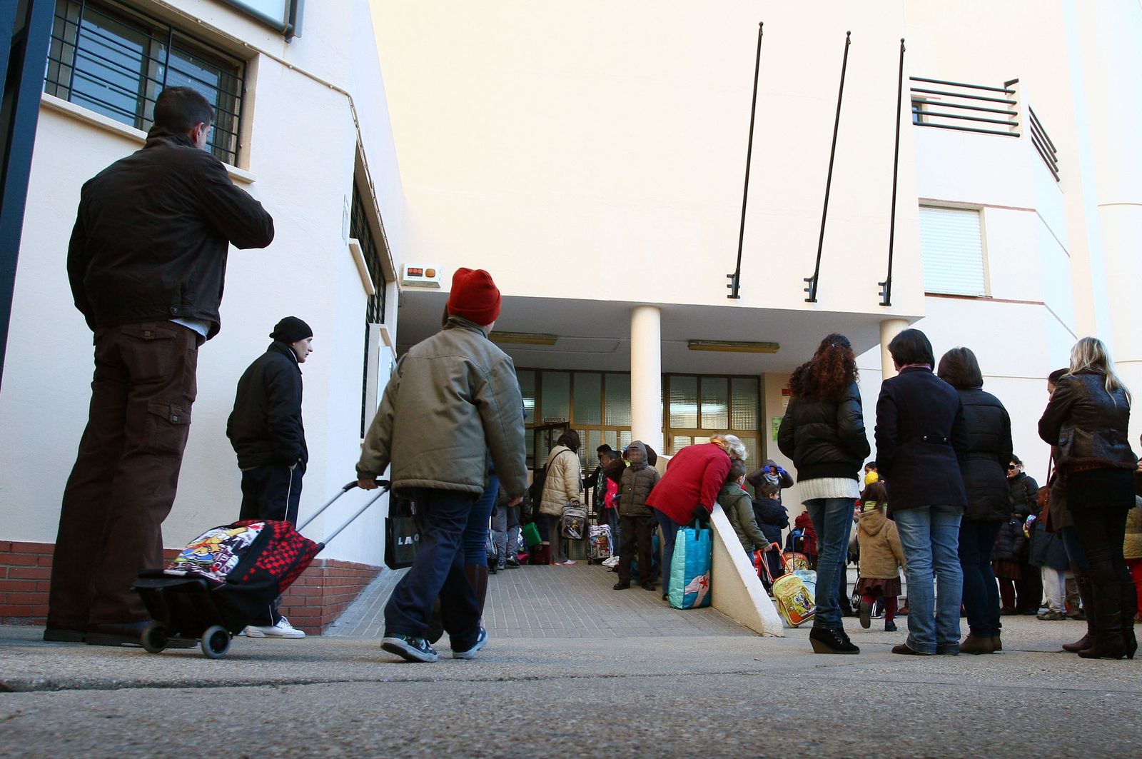 Entrada de alumnos a un colegio durante el invierno.