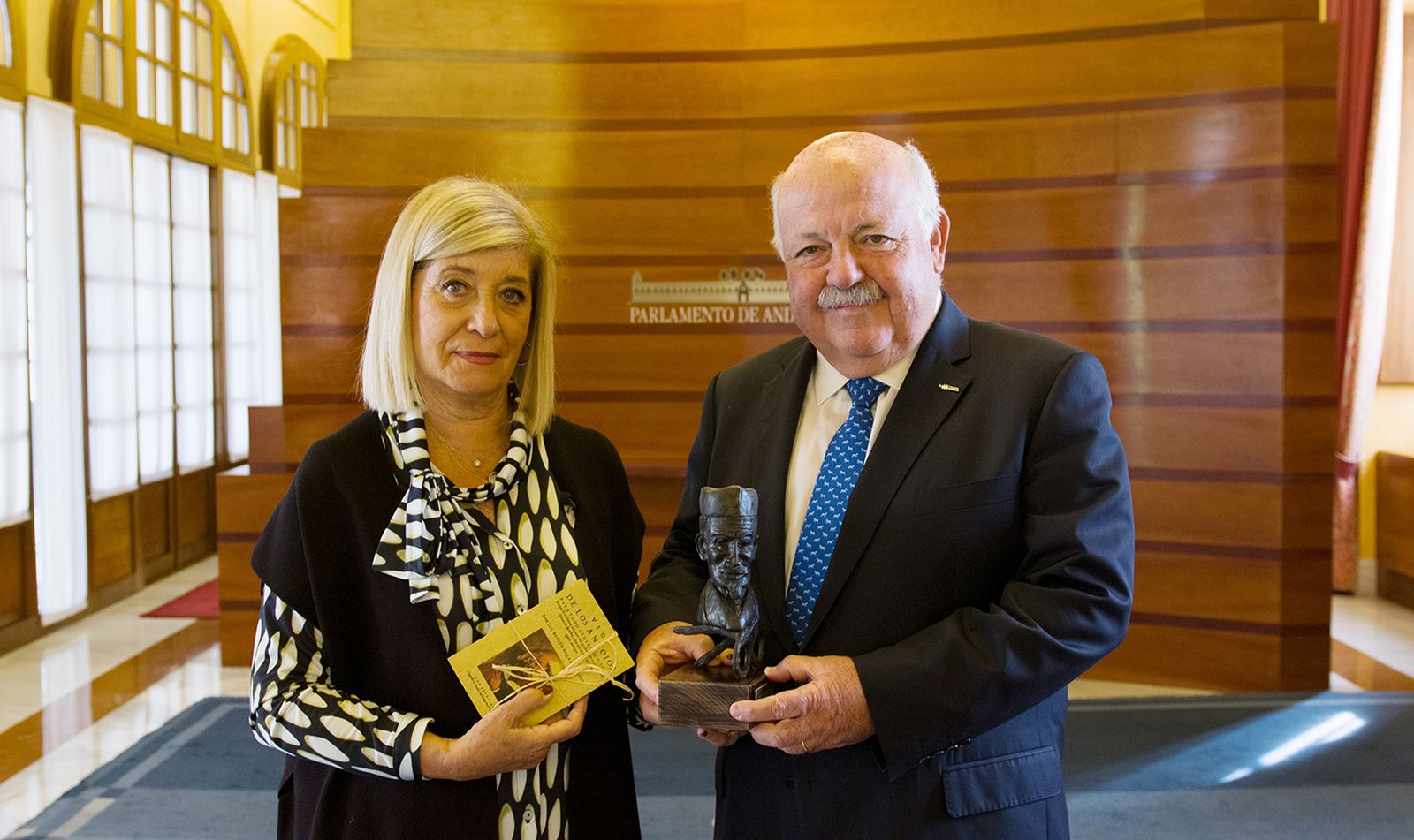 Blanca Fernández, presidenta del COOOA, hace entrega a Jesús Aguirre de la Mención Honorífica.