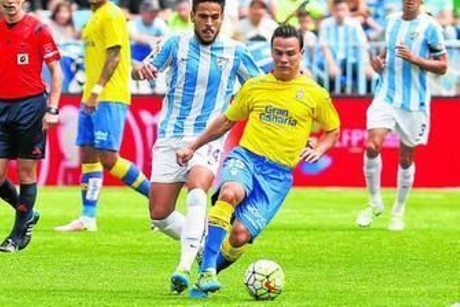 Roque Mesa condude el balón ante la presencia del malaguista Recio.
