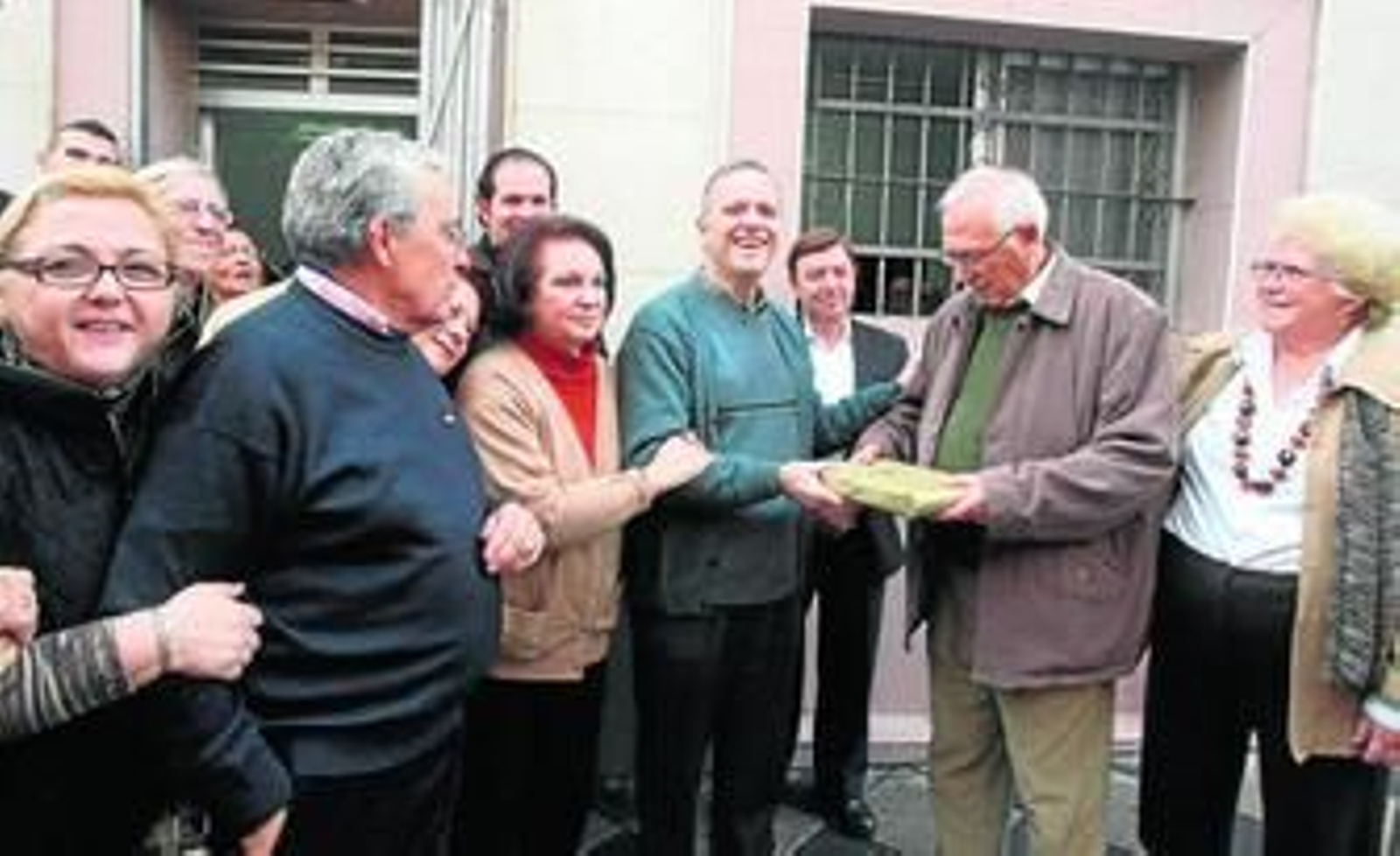 Juan Díaz-Pintado, en el centro, recoge el obsequio de los comerciantes de manos de Pérez, rodeado por familiares y amigos.