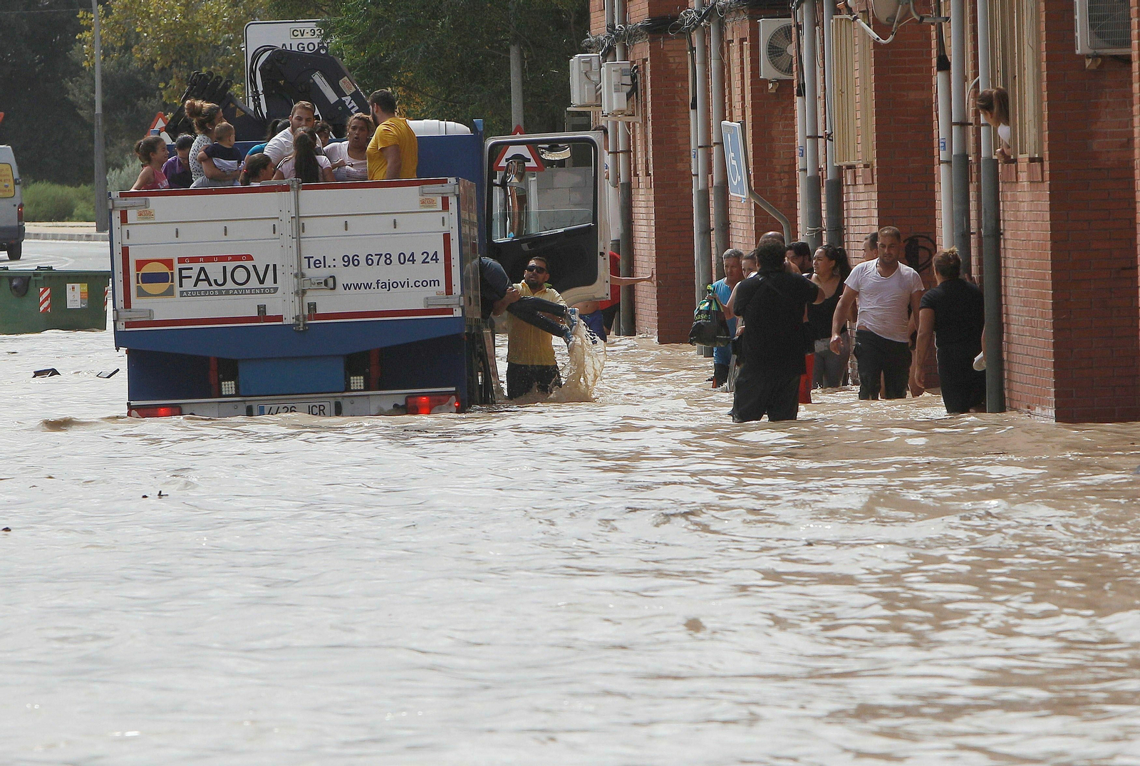Un camión traslada a varios vecinos de la localidad alicantina de Almoradí tras desbordarse el cauce del río Segura por la crecida.