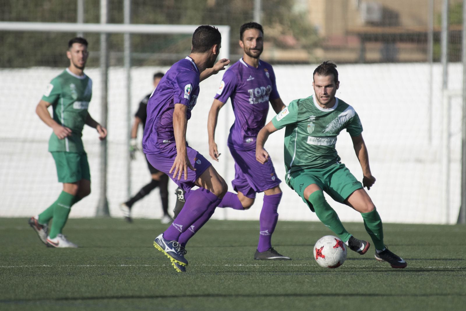 Álex Ortega intenta realizar un regate a un jugador del Jaén.
