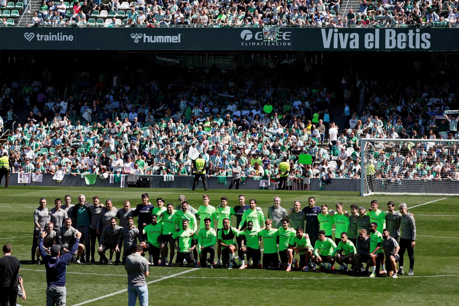 La plantilla, Pellegrini y su cuerpo técnico, y miembros de otras áreas cercanas a los jugadores posan sobre el césped del Villamarín.