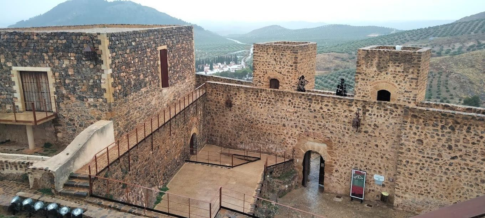 El patio de armas del castillo visto desde una de sus torres con un fondo protagonizado por la Sierra Sur de Jaén.