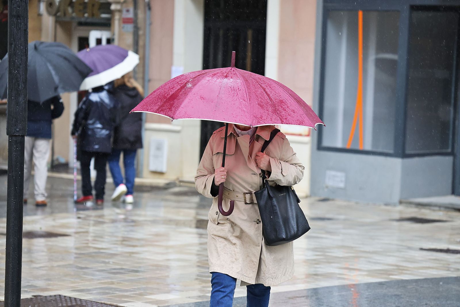 Una persona se refugia de la lluvia en Huelva.