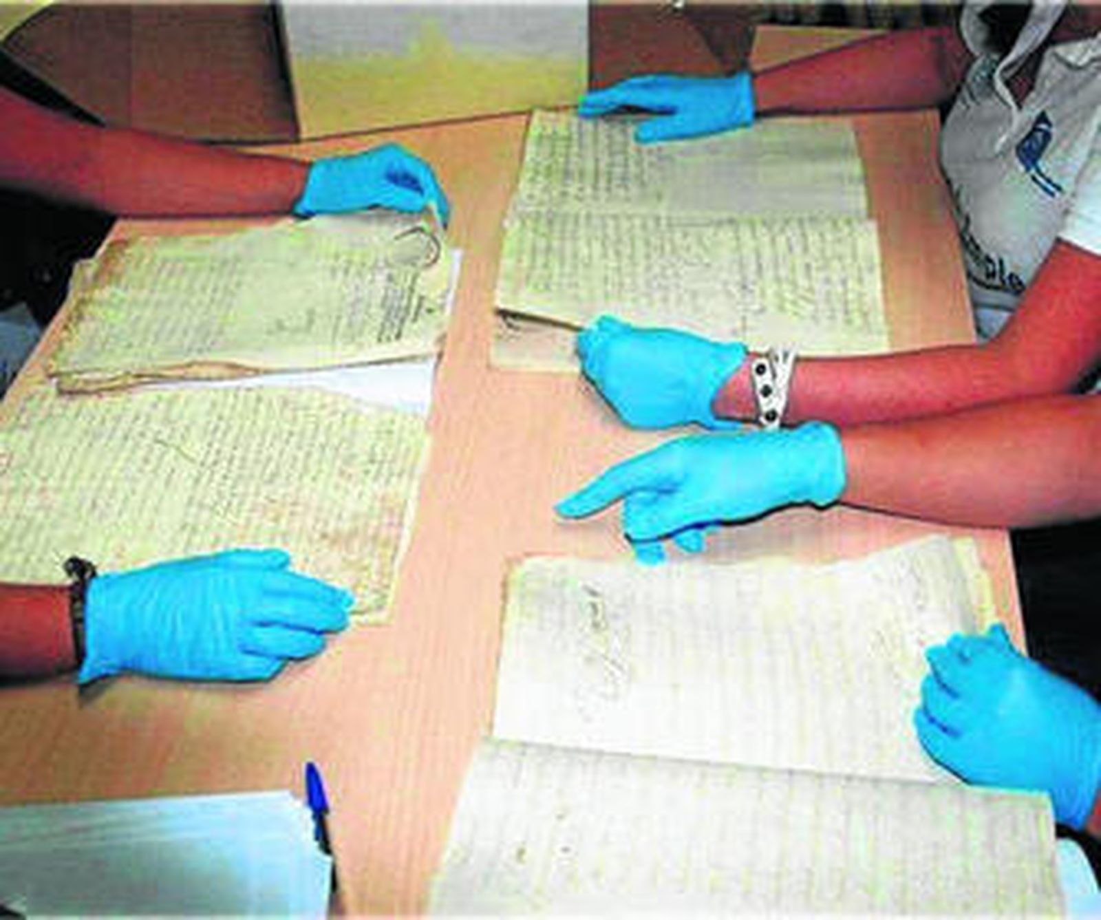 Los alumnos del taller manipulan los documentos con mucho cuidado.