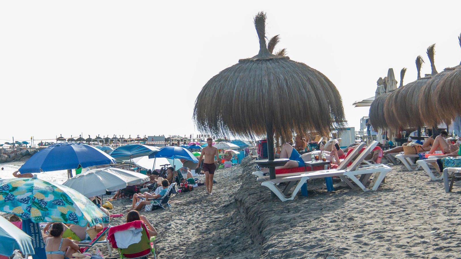 Una persona camina entre el escalón que ha surgido en Playa Granada