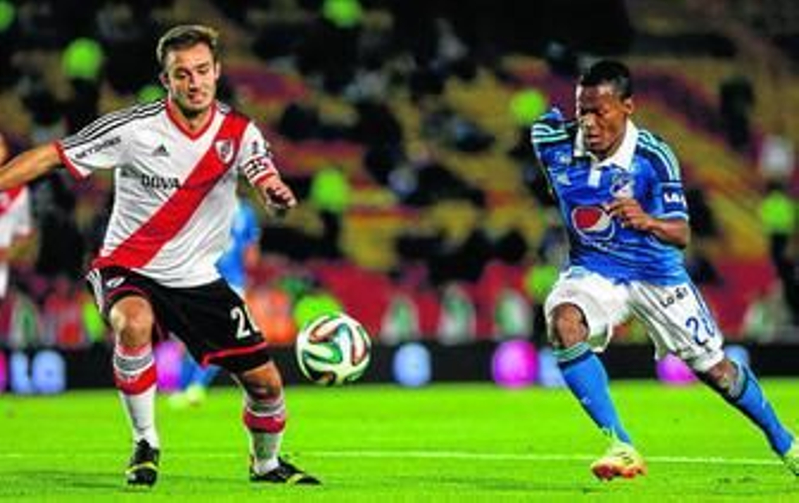 Pezzella intenta frenar a Álex Díaz durante un amistoso entre River y Millonarios.