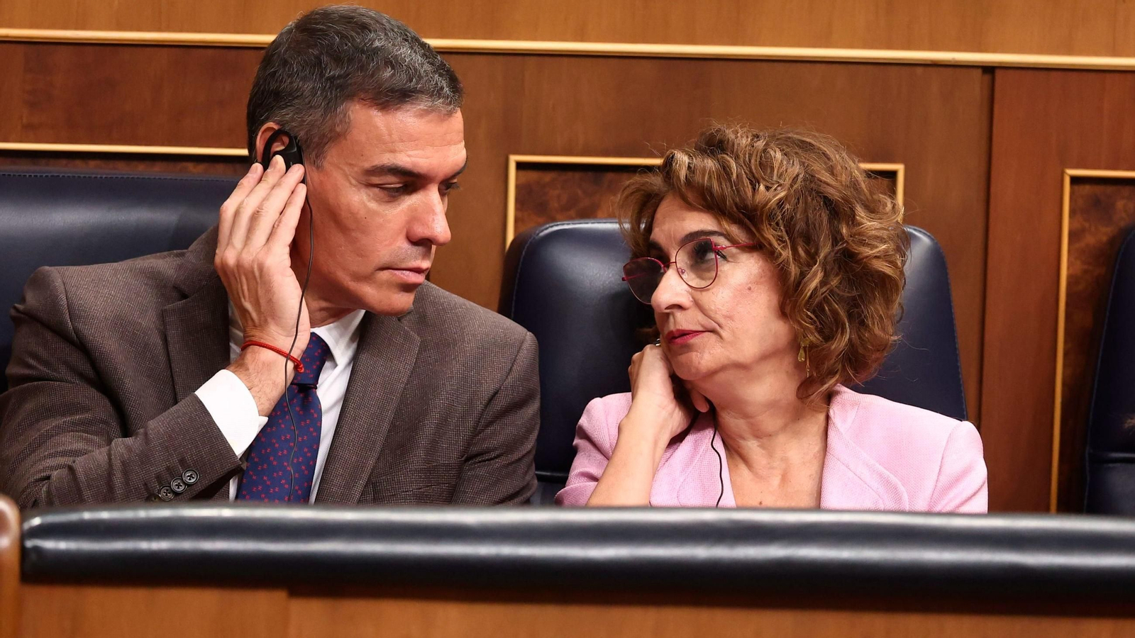 Pedro Sánchez mira a María Jesús Montero mientras escuchan la traducción de las amenazas de Míriam Nogueras, el miércoles en el Congreso.
