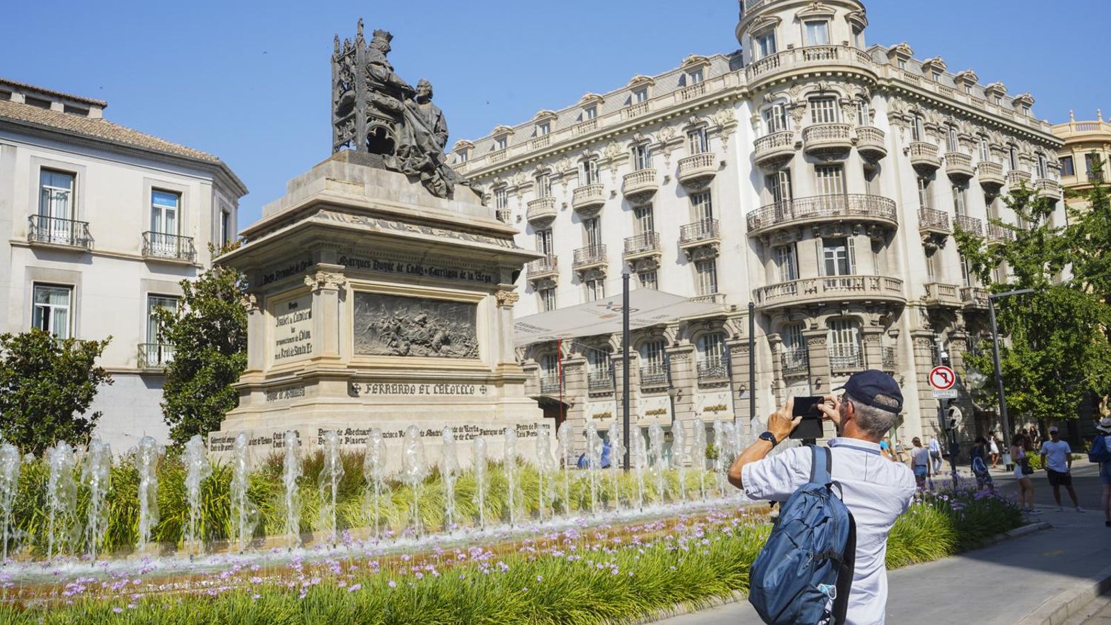 Un turista fotografía el Monumento de Colon e Isabel La Católica en el centro de Granada