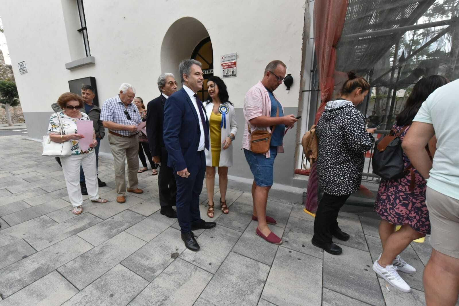 Azopardi, con traje azul, en la cola para votar en Gibraltar este jueves.