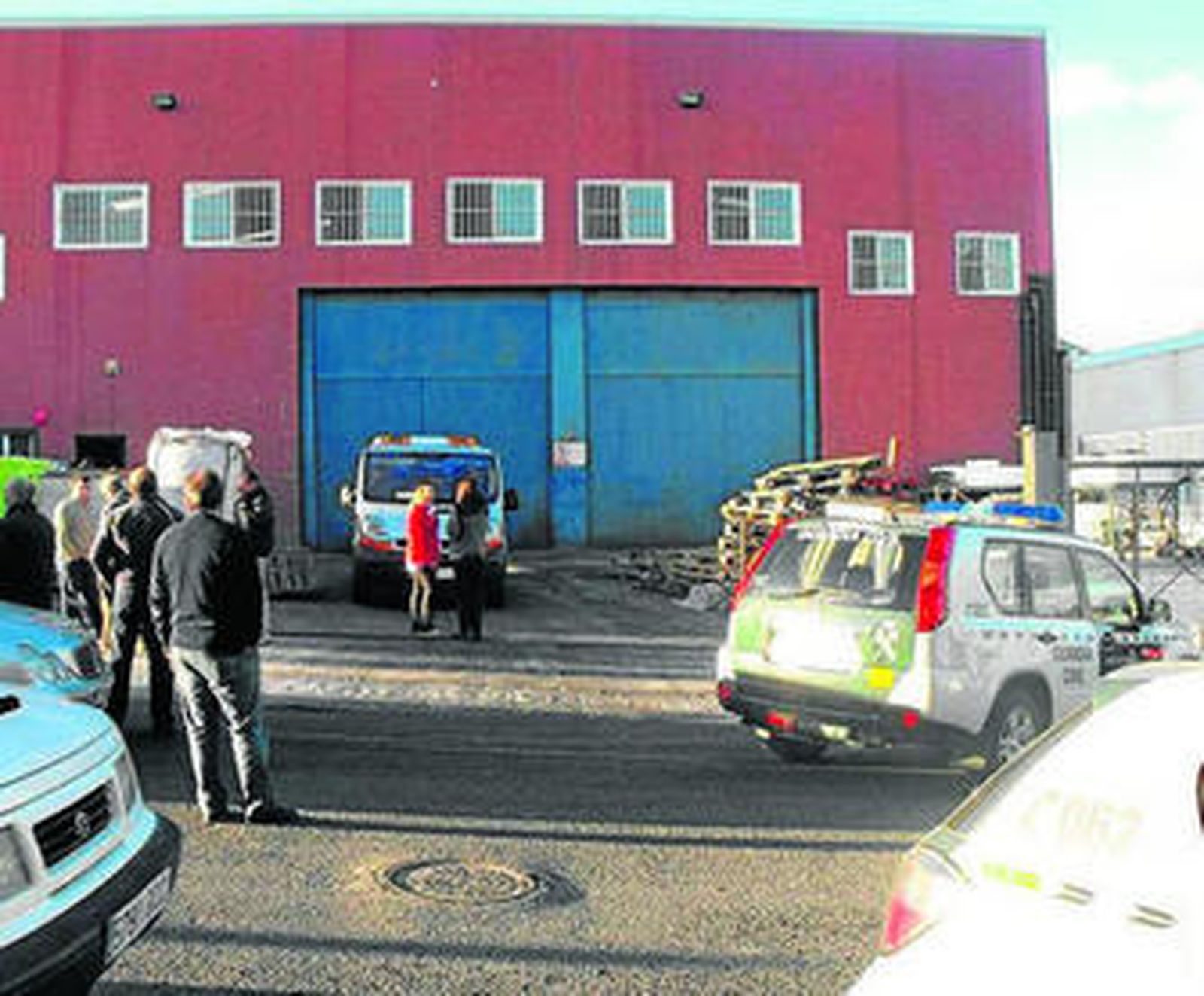 La familia espera en la puerta de la nave el levantamiento del cadáver.