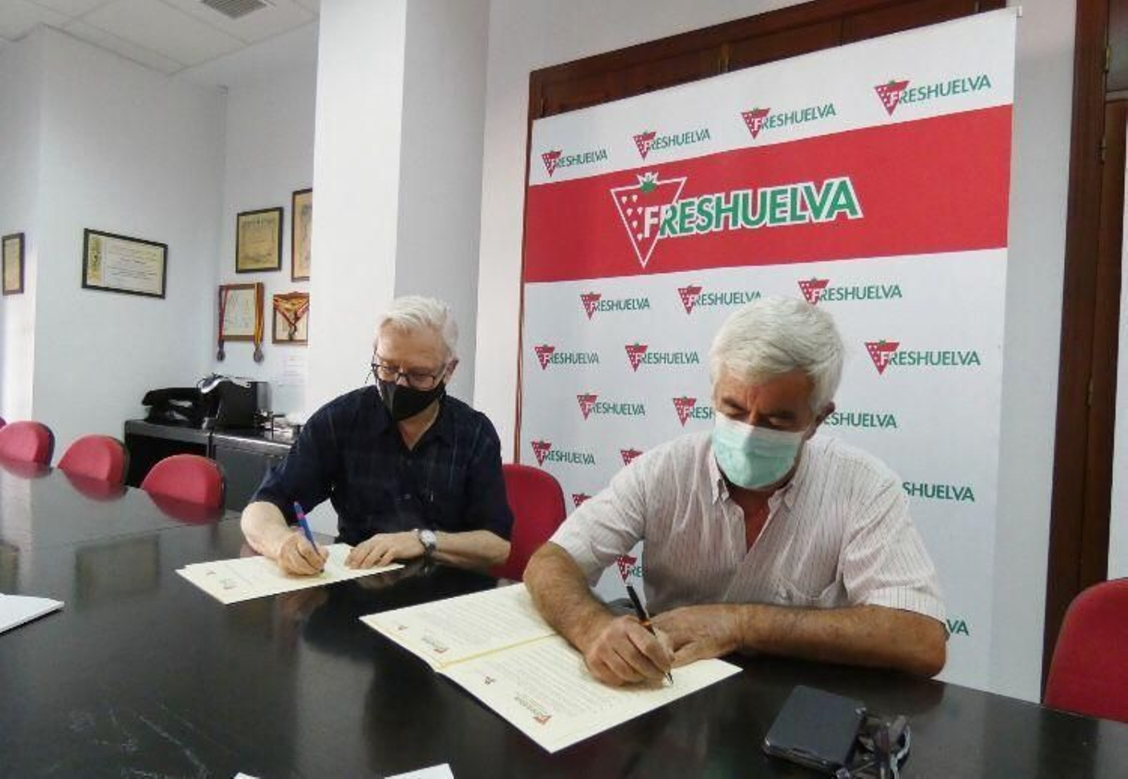 Los presidentes de Freshuelva y la Fundación TAU, respectivamente,  firmando el convenio.